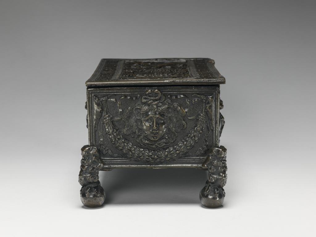 An image of Metalwork. Writing casket. Bronze, cast, height, whole, 10.2 cm, circa 1475-1525. The lid is associated, and the feet were added in the 19th century. Production Note: When purchased in 1937 the casket was attributed to Caradosso. Renaissance.