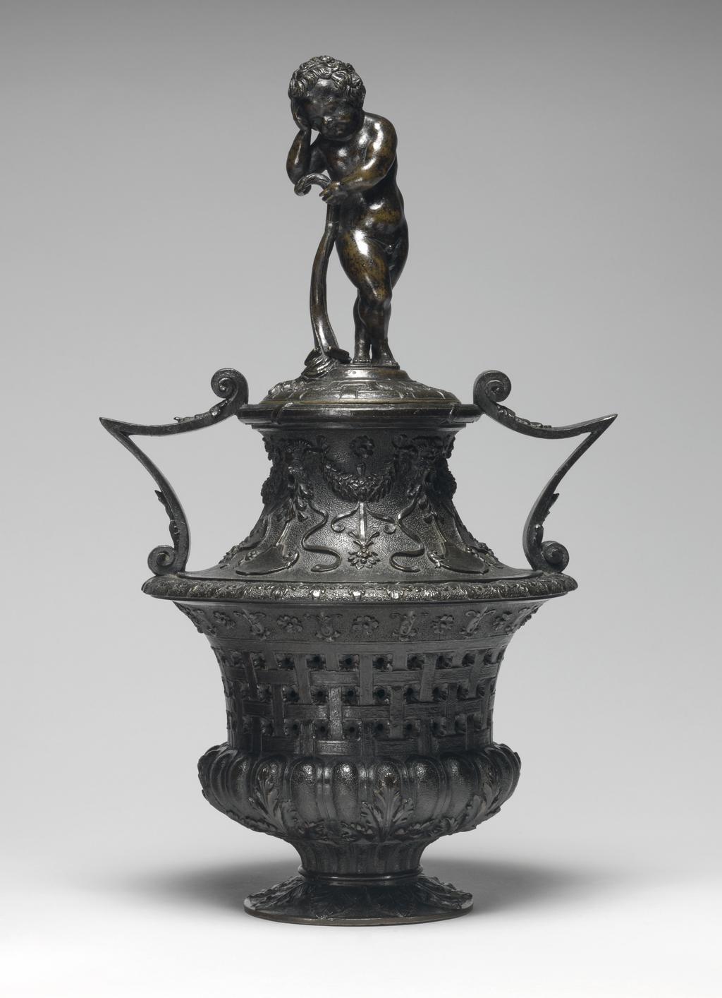 An image of Cassolette and cover with a funerary genius. Vincenzio Grandi (Italian sculptor, 1493-1577/78), and/or Gian Girolama Grandi (Italian, 1508-1560). Vase-shaped, with pierced sides, and two v-shaped handles, the cover surmounted by a standing putto leaning on an extinguished torch. Copper alloy, probably bronze, cast, height, whole, 34.1, cm, 1530-1560. Renaissance.
