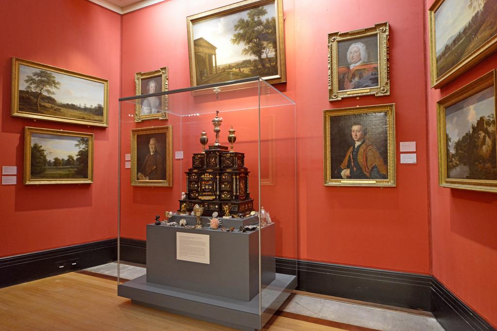An image of Augsburg 17th century silver-gilt mounted ebony Table Cabinet with Florentine pietre dure plaques from the Grand Ducal workshops. Boscher, Elias (1600-1674). Of architectural form, the stepped superstructure fitted with three frieze drawers above a central cupboard door, architectural pediment and inset with a panel depicting a chaffinch on a fruiting bough, flanked by columns of Smaragdite Gabbro with Corinthian capitals flanked by two deep drawers, inset with panels depicting parrots within fruiting boughs, with three further fitted drawers below, the large central cupboard door inset with a panel of a lapis lazuli flower filled urn issuing stems including a carnation, anemone, daffodil and lilies and enclosing an architectural interior, flanked by further Smaragdite Gabbro Ionic columns and three drawers to each side inset with further symmetrical floral panels including tulips, roses, carnations, lilies and bluebells, on shaped bracket feet, each side inset with large central panels of parrots on fruiting boughs, with four further floral panels above and below, the reverse veneered in kingwood, amaranth and stained walnut in geometric stellar designs. The cabinet containing a complex series of fourty-four secret drawers and compartments to the interior. The cabinet is signed in pencil on the underside 'Elias Boscher' and 'gemacht'. The central cabochon mount stamped with the Augsburg town mark and the silversmiths mark of Johann Spitzmacher (active 1655-1678). The front bears the ebony stamp "EBEN" with the pinecone of Augsburg. Height 85 cm, width 84cm, depth 40cm, circa 1660.
