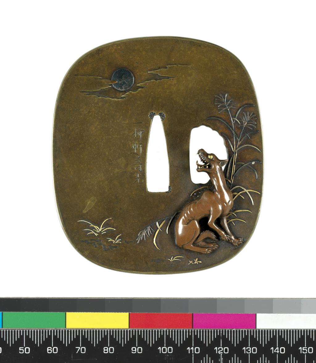 An image of Sword fitting. Tsuba. Sentokudo. Squarish. A wolf seated on the ground among reeds, gold and silver zogan, turning round and baying at the moon, silver, among clouds. The wolf's teeth beautifully cut in gold. On the other side a kasa lying on the grass all gold zogan. Signature: Ichiiriuku Hisamitsu. Gold, silver, height, whole, 8.4 cm, width, whole, 7.5 cm. Japanese.