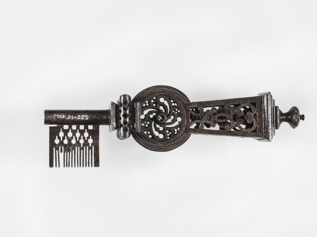 An image of Key. Iron, double-piped stem, ornately pierced, with fine comb wards, bearing the initials ‘P.F.’.  French. Circa 1600-1700.