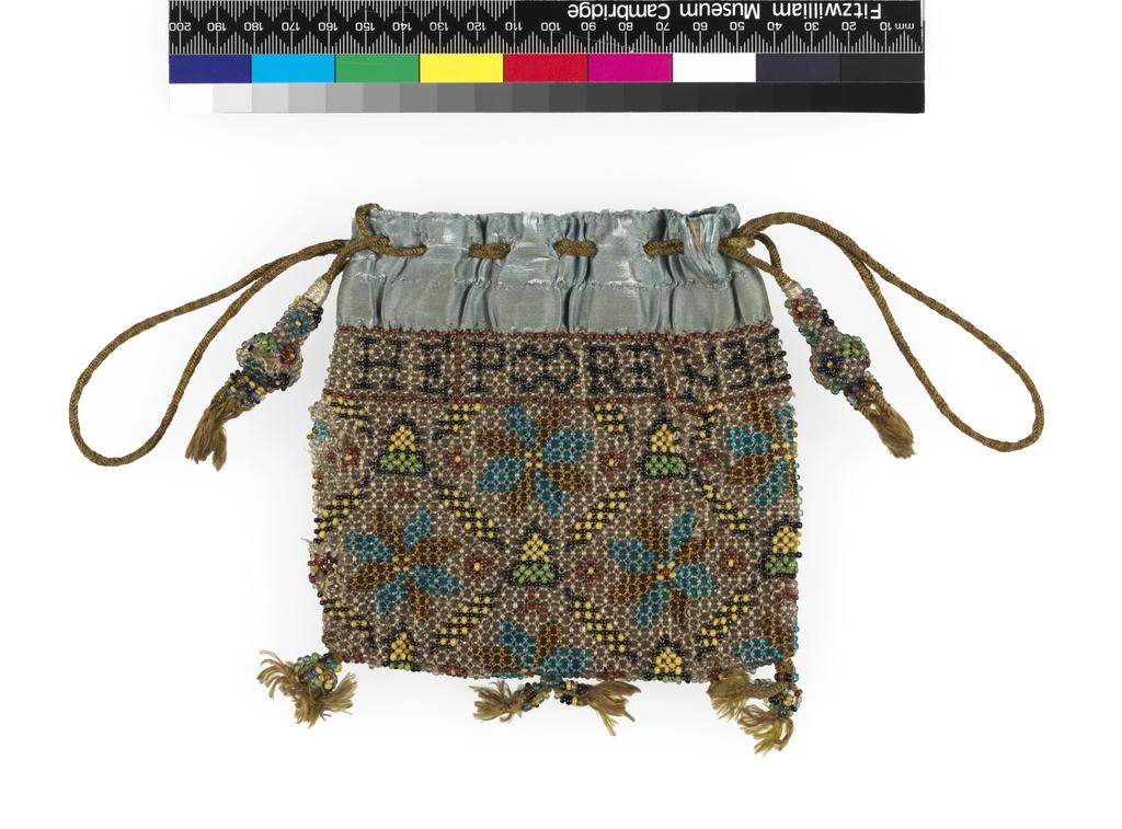 An image of Textiles. Purse. Unknown maker. Beads (opaque black, yellow, green and brick red; clear blue and gold) threaded on natural silk threads. Lined in leather, bound at top with pale blue satin. Around the top RE / MEMBER / THE / POOR / 1631. Cords for hanging and draw strings, pear-shaped beaded drops, each with two small tassels, three pairs of tassels on bottom edge. Height, whole, 5 in, width, whole, 5 in, 1631. English.