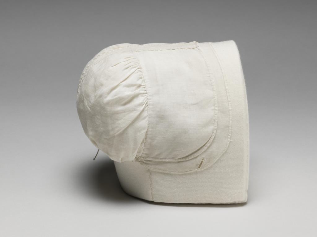An image of Textiles. Infant's bonnet. Linen, inset with hollie-point. The bonnet is made in five pieces: a brim, a plain ungathered frill in two pieces, and two back sections. Inset between the two pieces of the frill there is a strip of hollie-point worked with the words 'SWeeT BABe'. Inset between the two back sections there is a strip of hollie-point worked with coronets. There are two draw strings across the lower edge at the back, tying in the centre, and a button hole on the right side of the brim. Circa 1700-1799. English.