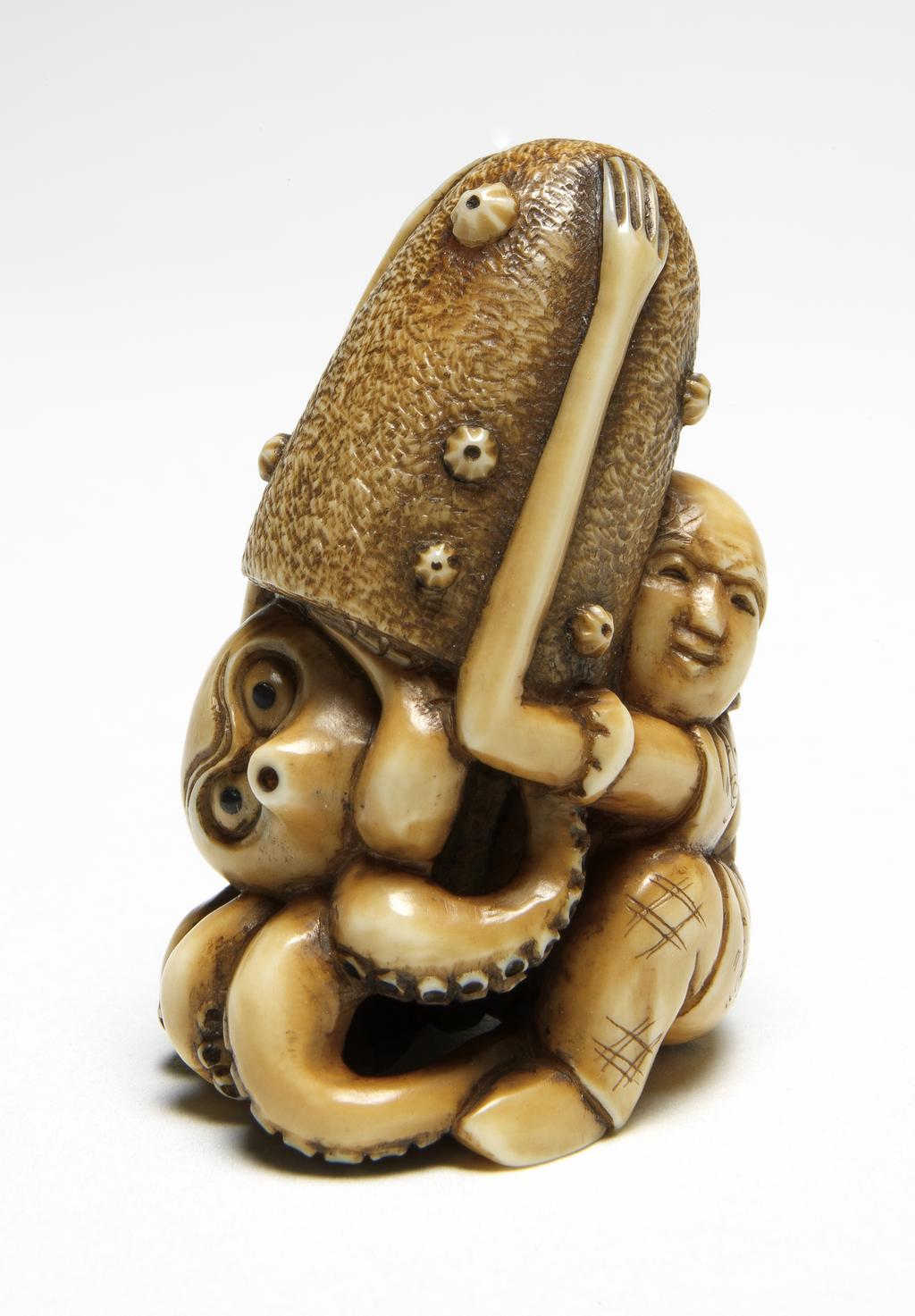 An image of Netsuke. A seated Tenaga (long arms) with octopus and octopus trap. Ivory, carved, 1850-1900. Japanese.