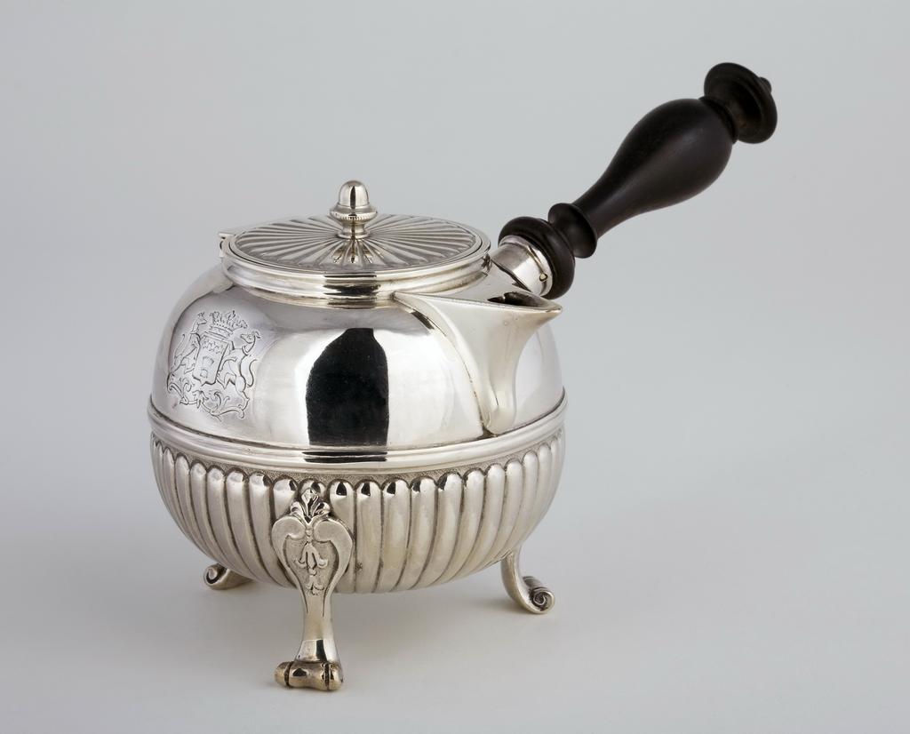 An image of Chocolate Pot/Teapot/Hot Milk Jug. Delapierre, Michel II (French, Paris, master 1737, recorded 1785). Half fluted almost spherical body with wood handle. The short beak-like spout has a heart-shaped opening. The hinged cover is flat and gadrooned, and has a acorn-shaped finial. The jug stands on three scroll legs with fleur-de lis, scroll and flower capitals. Opposite the handle is engraved a coat-of-arms. Silver body, raised, embossed and matting with engraved armorials, cast finial and legs, wooden handle, height, to top of finial, 9.4 cm, width, side to handle, 15.8 cm, weight, gross, 190 g, 1758-1759. Louis XV.