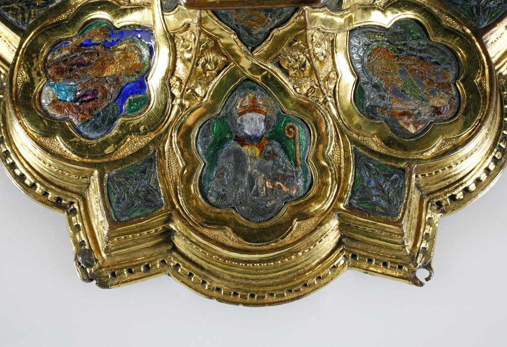 An image of Silver/Church Plate. Chalice. Petruccio Campagnini, Andrea, probably (active Tuscany, Siena, Italy). Set with six silver medallions of Christ, St Peter, St. Paul, St. John, St. Bartholomew and possibly St. Barnabus. Above the knop the stem is engraved with six male busts without nimbi; below the knop the stem is engraved with six birds. At the base of the stem are moulded borders containing a plain band engraved and enamelled with the inscription 'ANDREA * PETRUCI * DE * SENIS * ME *FECI(T). The low copper-gilt trumpet-shaped foot has a shaped circular spreading base with rim of twelve alternating semicicular and pointed lobes. It is set with six applied silver plaques with translucent enamels on sunk relief, representing the Crucifixion with Instruments of the Passion, on either side of which are the Virgin and St. John; on the opposite side are a bishop with mitre and crozier between a male and female saint. Above are smaller shaped triangular plaques enamelled with the heads of angels; and below are lozenge shaped plaques enamelled with a stylised leaf. The base stands on a foot ring decorated with moulded, beaded and dentil borders. Bowl silver-gilt with silver calyx, foot and stem of copper-gilt, decorated with embossing and chasing, and set with silver plaques with basse taille enamelling, height, overall, 19 cm, diameter, base, 12.8 cm, maximum, diameter, rim, 9.9 cm, circa 1370. Late Medieval. Gothic.