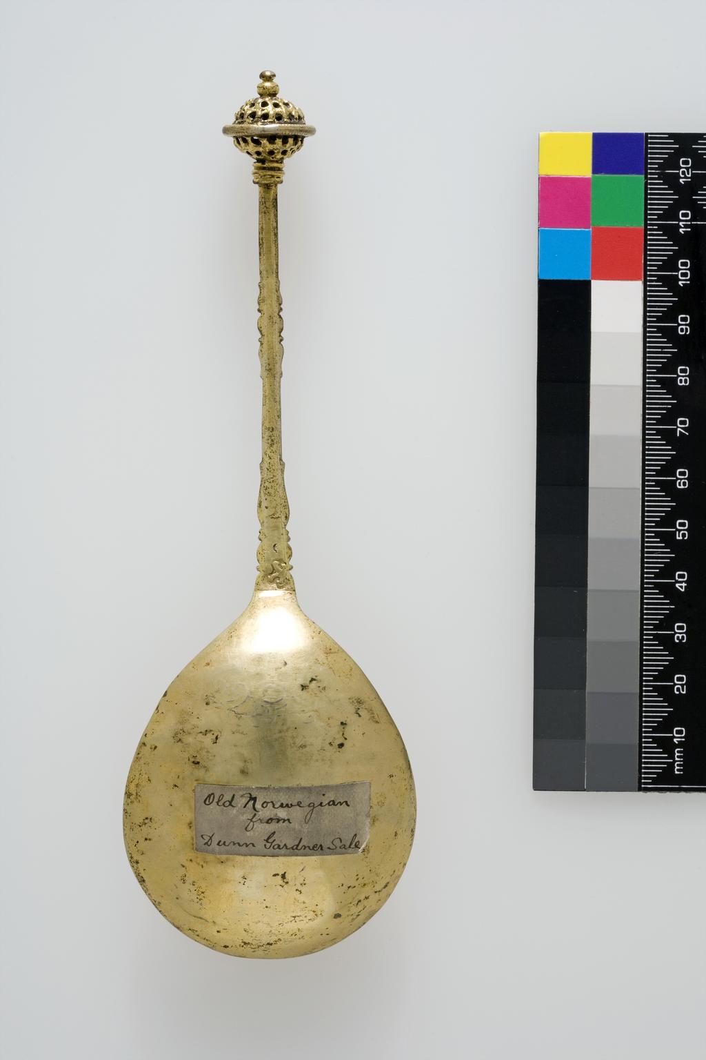 An image of SpoonSilver-gilt; the front of the fig-shaped bowl is engraved with a pattern of strapwork.  The slender handle is square in section and decorated on the front and sides of the base and centre with moulded balusters.  The finial is an openwork ball with girdle.ScandinaviaC.1600