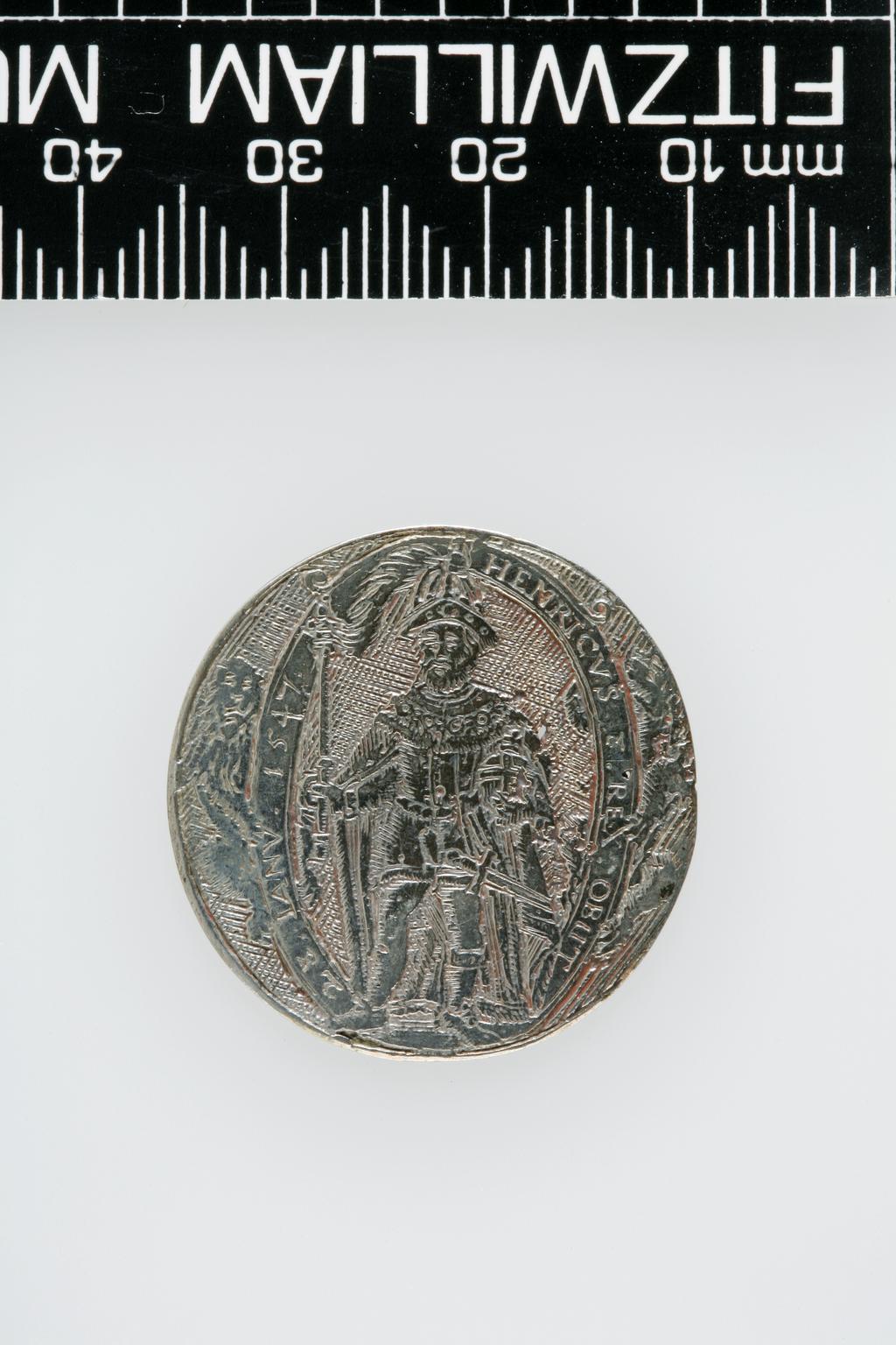 An image of Counter Box containing 32 countersCounter box. Silver, the box pierced, chased, and engraved, containing thirty-two engraved silver counters of English monarchs and their childrenCounter box. Silver, the box pierced, chased, and engraved; the counters engraved. The box is cylindrical with a detachable lid. The base is decorated with a bust of Queen Henrietta Maria in profile to left in low relief in an open oval medallion with pairs of inwards scrolls above and below, and S-scrolls on either side, with a cut away background. The top bears a bust of Charles I in profile to left in an open oval medallion surrounded by four paired scrolls with single scrolls between them, with a cut away background. The sides have two panels each containing pierced scrolling foliage and a monster. The counters are circular, and are engraved with monarchs and coats-of-arms respectively on the two sides: Prince Charles (d. 1130), Edward the Confessor, Willima I (2), William II, John, Edward I, Edward II, Edward III, Edward IV, Edward V, Edward VI, Henry I, Henry II, Henry III, Henry IV, Henry V, Henry VI (2), Henry VII, Henry VIII, Richard I, Richard II, Richard III, Mary I (2), Elizabeth I, Henry father of King James I and VI, James I and VI, Charles I, Elizabeth of Bohemia (his sister), Charles Louis Count of the Palatinate (her son)EnglishC.1640-50