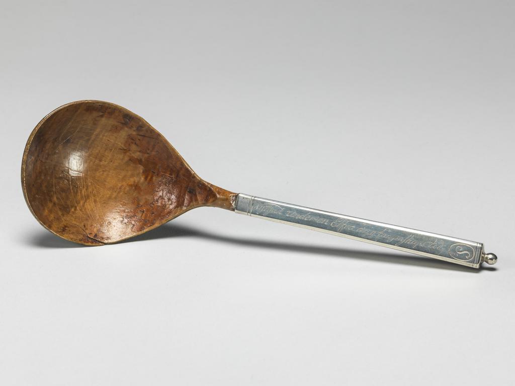 An image of Cutlery/Spoon/Flatware. Unknown silversmith and carver. The wood bowl on a silver handle square in cross section and inscribed. The wood bowl is fig-shaped on a short stem. The silver handle is square in cross section and broadens slightly towards the terminal, which has a small ball finial. The bowl of the spoon is varnished and may once have been painted. The front of the handle is inscribed 'Nyttjad under en Elfra årig fångenskaps tid' and initialled 'S'. The seam on the silver handle was soldered and the finial soldered to it. Fruit wood and silver, length, overall, 17 cm, circa 1650- circa 1800. Production Note: the handle may be later than the bowl of the spoon. Scandinavian. North European.