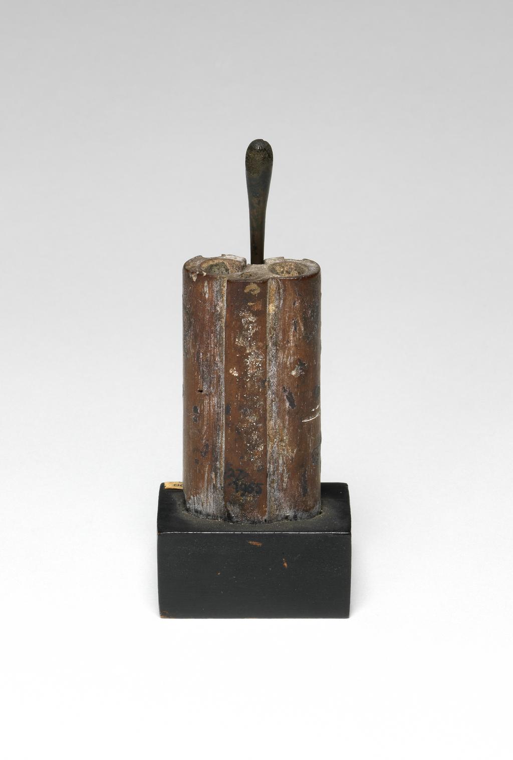 An image of Cosmetic equipment. kohl pot, with stick. Production Place: Egypt. Bronze stick, ebony inlay, ivory inlay, wood, length, 0.06 m, length, stick, 0.0875 m. New Kingdom.