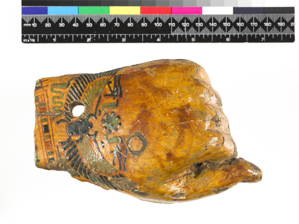 An image of Funerary equipment/cartonnage. Left hand, from a yellow coffin with winged scarab decoration. Production Place: Egypt. Find Spot: Luxor, Egypt. Wood, height 9.5 cm, width 15.9 cm, thickness 4.1 cm, circa 1070- circa 945 B.C. Third Intermediate period.