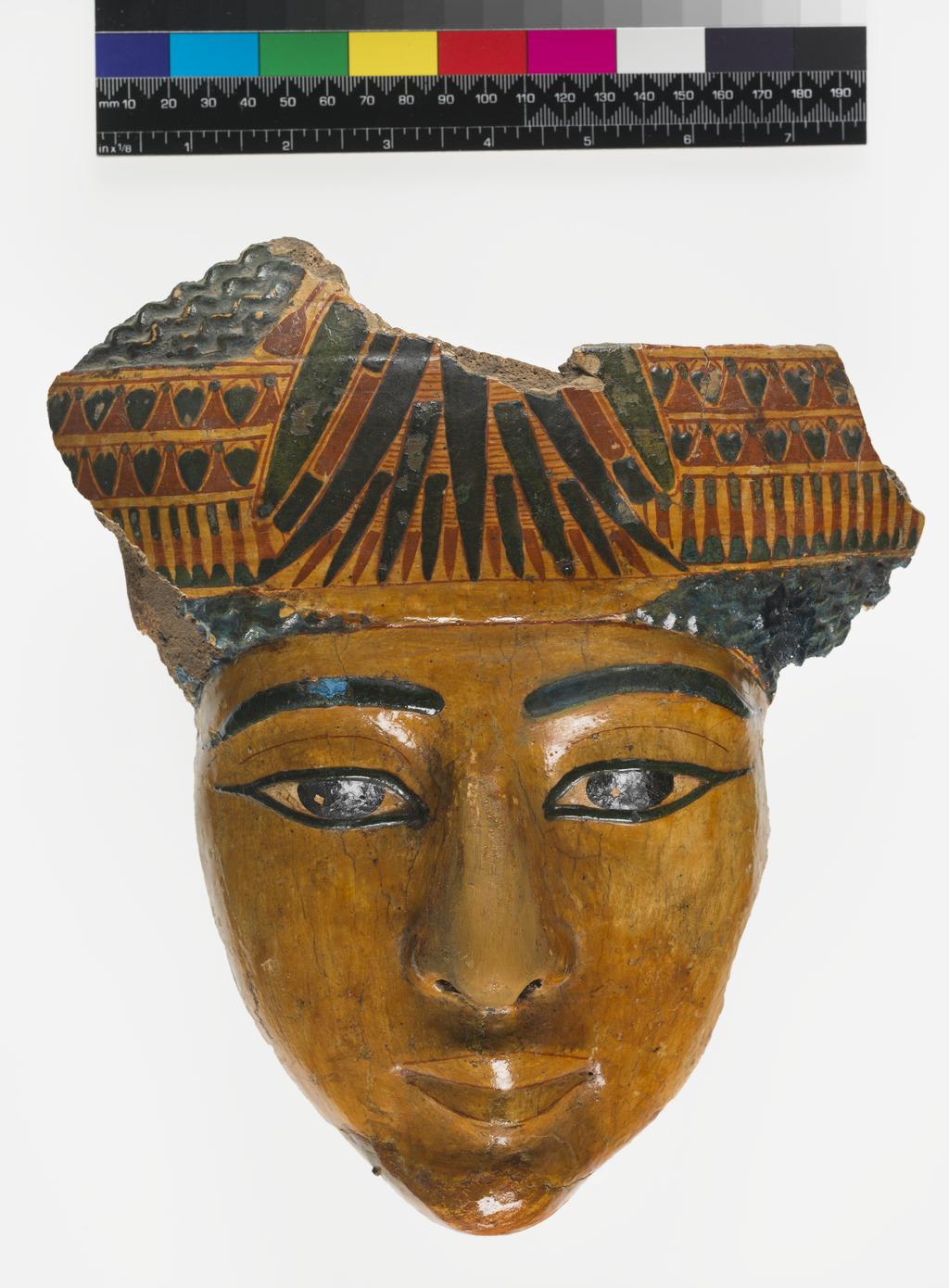 An image of Funerary equipment. Face from coffin, polychrome and varnished. Chin and nose heavily restored during the Twentieth Century. Production Place: Egypt. Find Spot: Thebes. Width 21.7 cm, height 24.6 cm, thickness 5.4 cm, 1070-735 B.C. (dating not confident). Twenty-first Dynasty. Third Intermediate period.