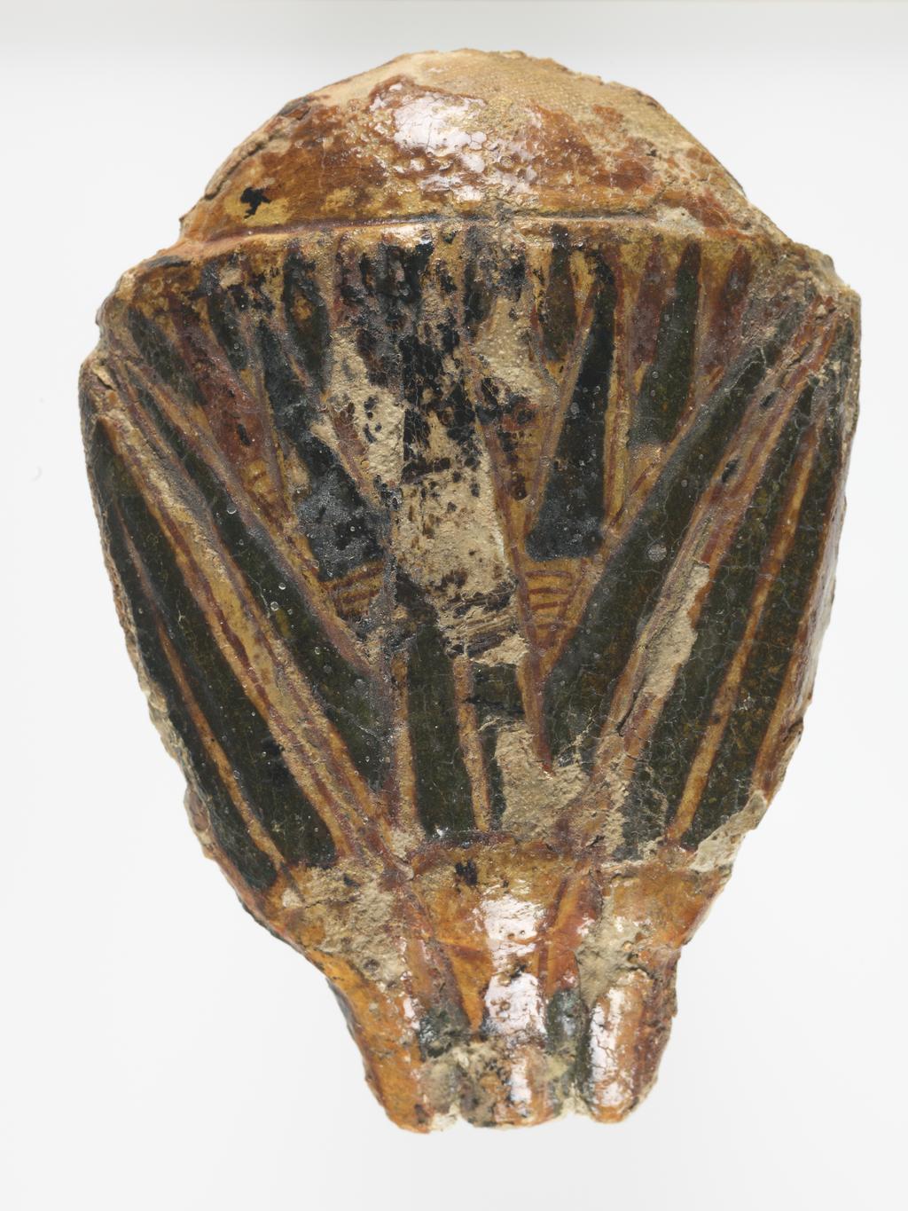 An image of Funerary equipment. Coffin fragment. Lotus flower from a coffin, orginally attached to the elbow of an anthropoid coffin. Production Place: Egypt. Wood, plastered surface, thickness 1.5 cm, height 10.9 cm, width 7.9 cm, 1070-945 B.C. Third Intermediate period.