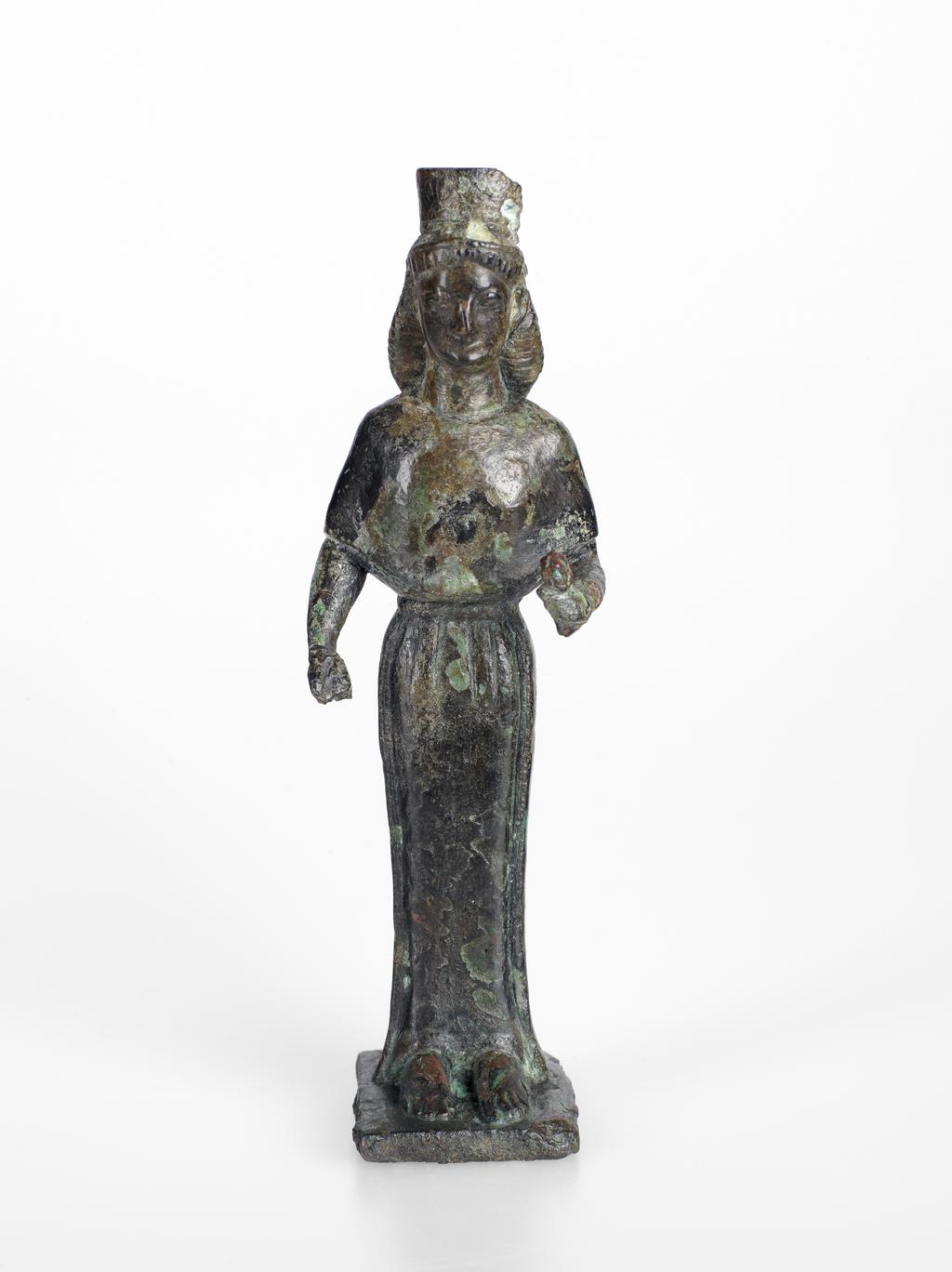 An image of Figure/Statuette of a woman, possibly Hera. Copper alloy, cast, height 0.135 m, width 0.041 m, depth (plinth) 0.034 m, 600-501 B.C. Production Place: Possibly Attica, Greece. Archaic Period.