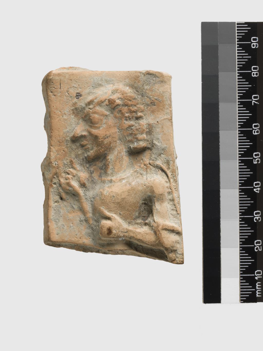 An image of Architectural element. Relief of charioteer. Find Spot: Praesos, Greek Islands, Crete. Clay, depth 0.01 m, height 0.07, m, width 0.048 m (max), 700 B.C. to 601 B.C. Archaic Period.