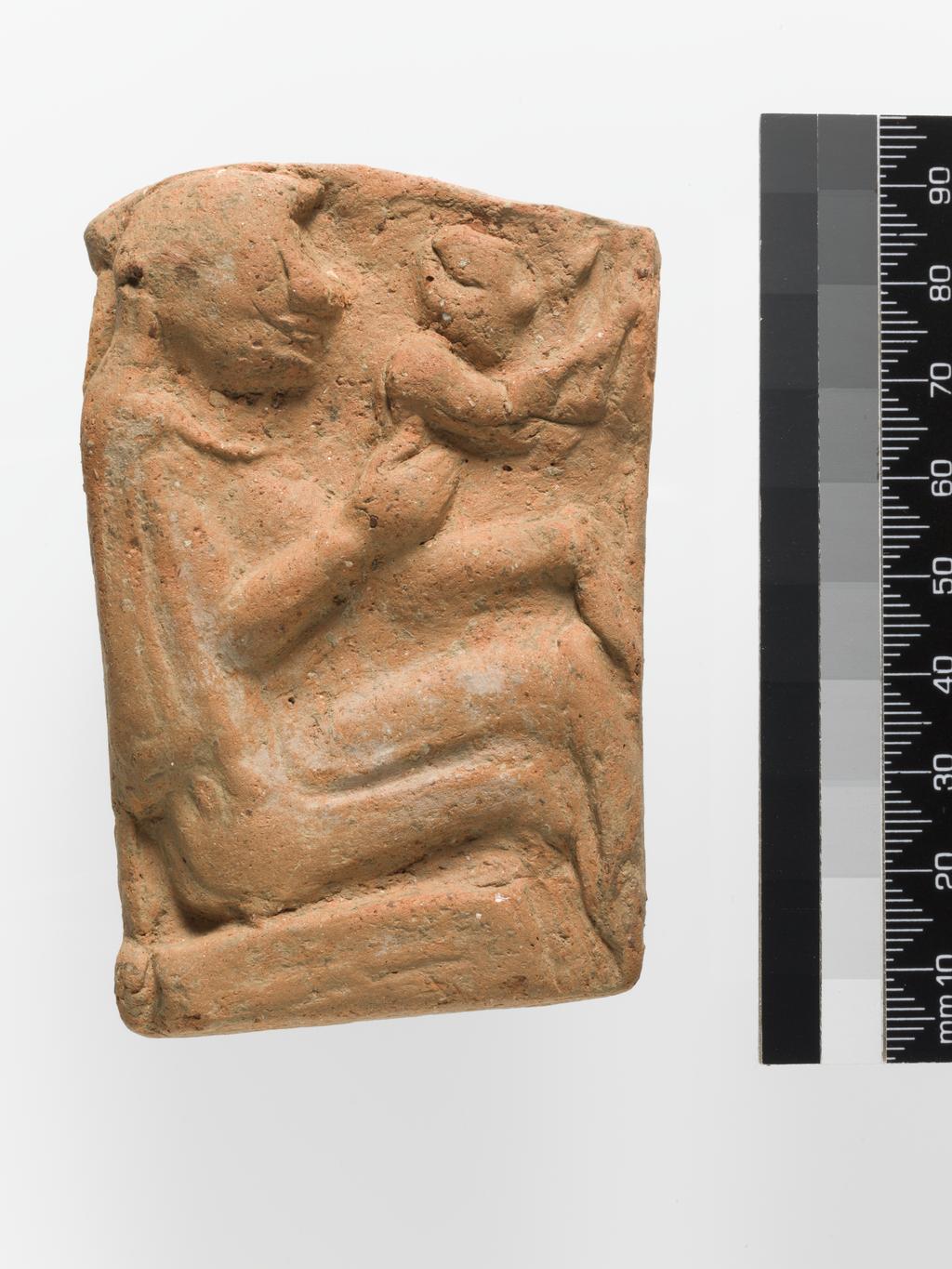 An image of Architectural element. Relief of woman and child. Find Spot: Lato (Goulas), Greek Islands, Crete. Clay, height 0.09, m, width 0.06 m, 700 B.C. to 601 B.C. Archaic Period.