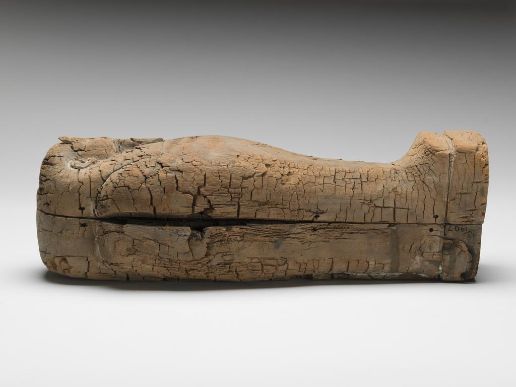An image of Funerary Equipment. Coffin. Miniature coffin, with embalmed object, possibly the body of an infant, coated in pitch inside. Production Place: Egypt. Find Spot: Gizeh, Egypt. Wood, length 43.8 cm, width 13.4 cm, depth 14.1 cm, circa 664- circa 525 B.C. Dating not confident. Late Period.