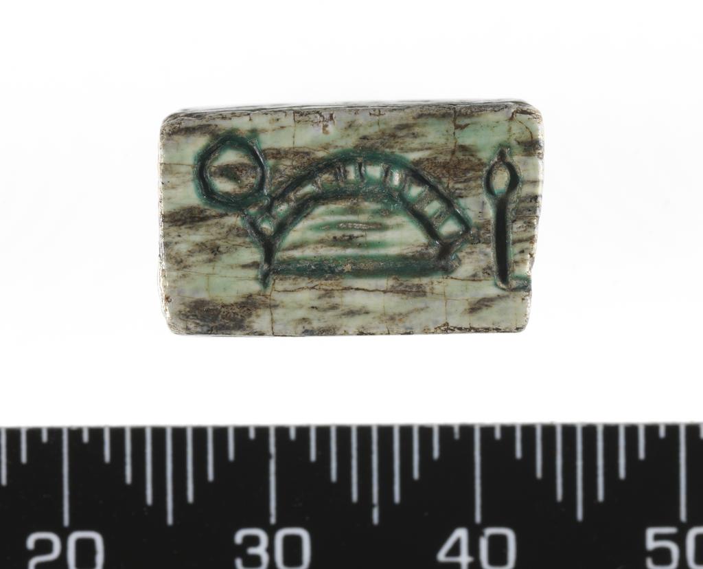 An image of Plaque or amulet/jewellery. Magic rod fragment? Rectangular, inscribed on four sides. Depth, 0.007 m, length 0.018 m, width 0.0105 m. Egyptian.