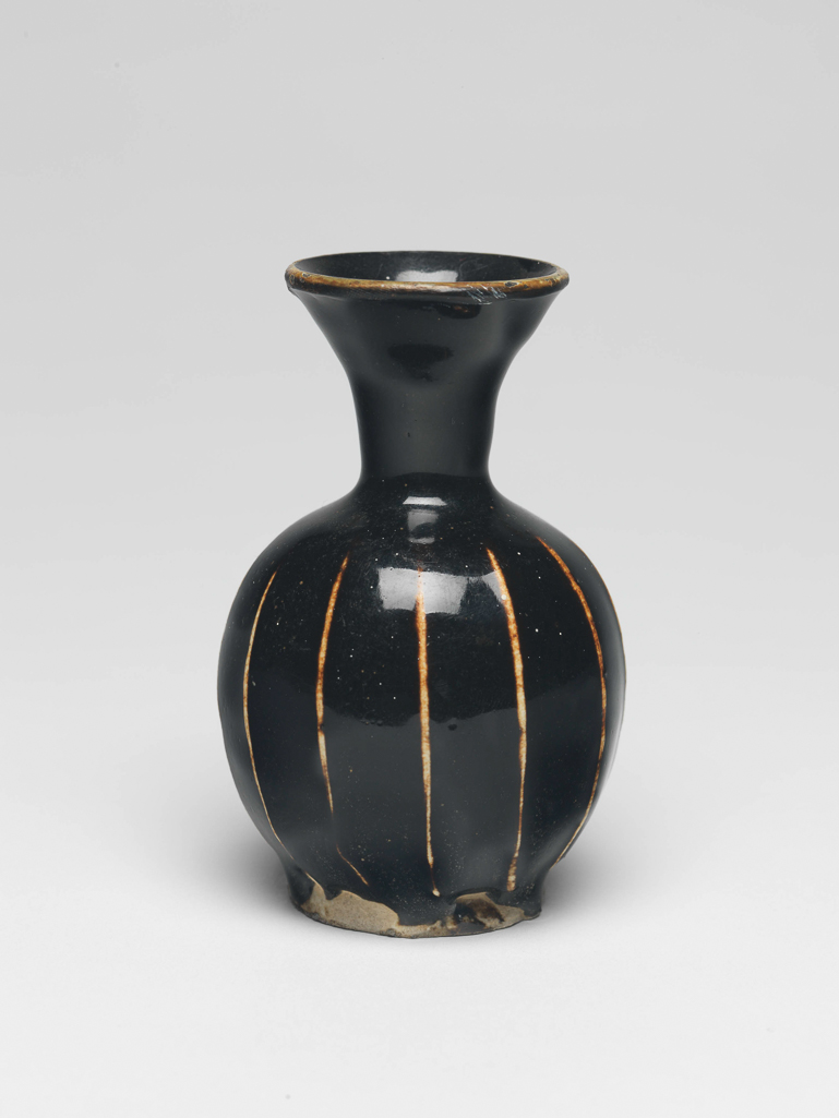 An image of Miniature vase. Henan ware. The vase has a bulbous body with a slender neck, flaring towards the rim, standing on a footring. Oval label printed in black with a tower, and 'Malcolm Collection' inscribed in blue black ink 'D./94'. Oval inscribed in black '125'. Stoneware, with applied white ribs and dark brown glaze. Unglazed base. Height 6.1 cm, 1000-1127. Northern Song (960-1127). Chinese. Acquisition Credit: Lent to the museum by Helen H. L. Whittow (nee Malcolm).