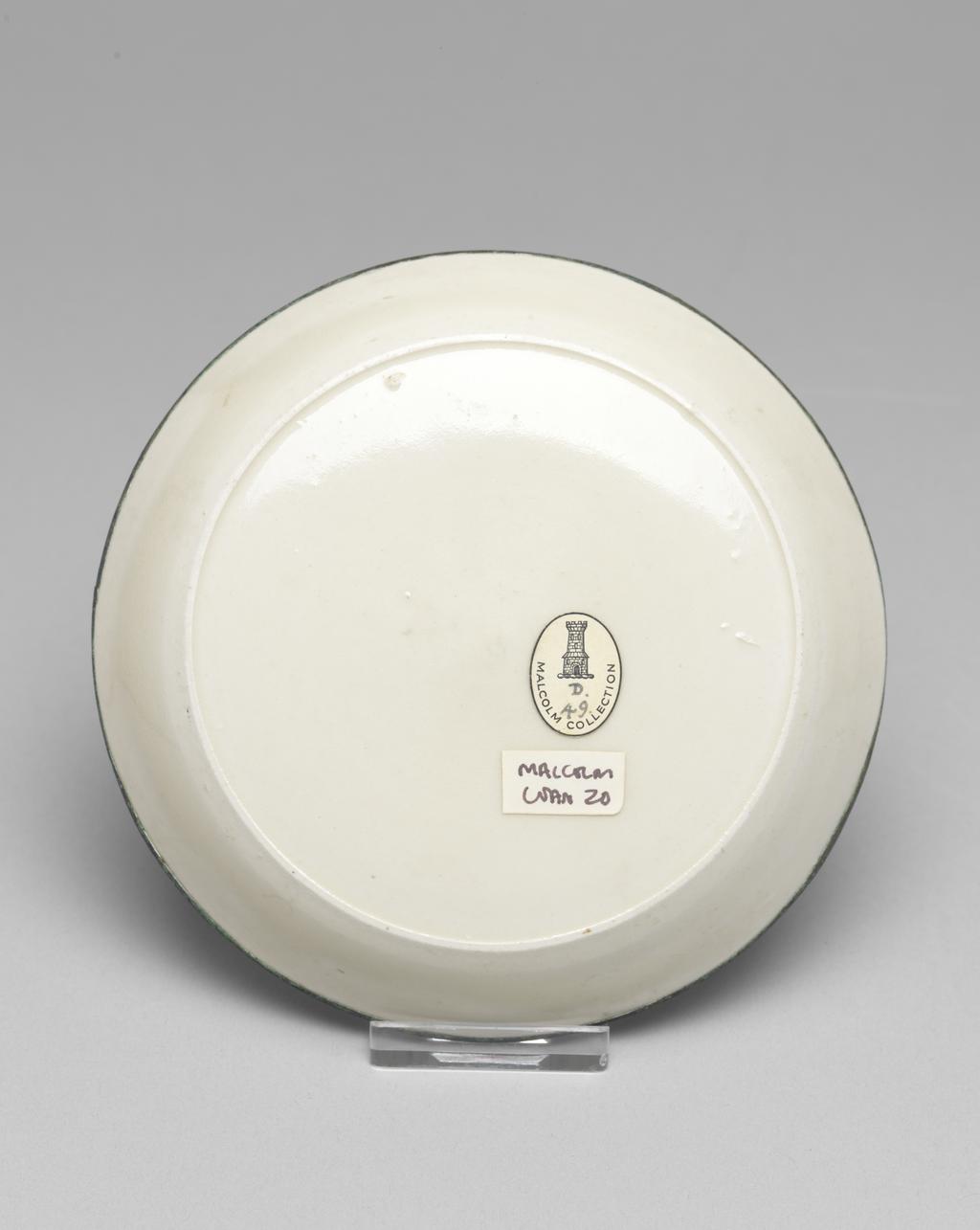 An image of Saucer. Ding Yao ware. The saucer is circular with shallow sloping sides. The flat centre is incised with a lotus flower and foliage. With an oval label printed in black, with a tower and 'Malcolm Collection', and inscribed in blue black ink with 'D./49'. White stoneware, with an incised decoration under the ivory white glaze, and a rim mounted in what may be copper. Height 2.5 cm, diameter 13 cm, 960- 1127. Northern Song (960-1127). Chinese. Acquisition Credit: Lent to the museum by Helen H. L. Whittow (nee Malcolm).
