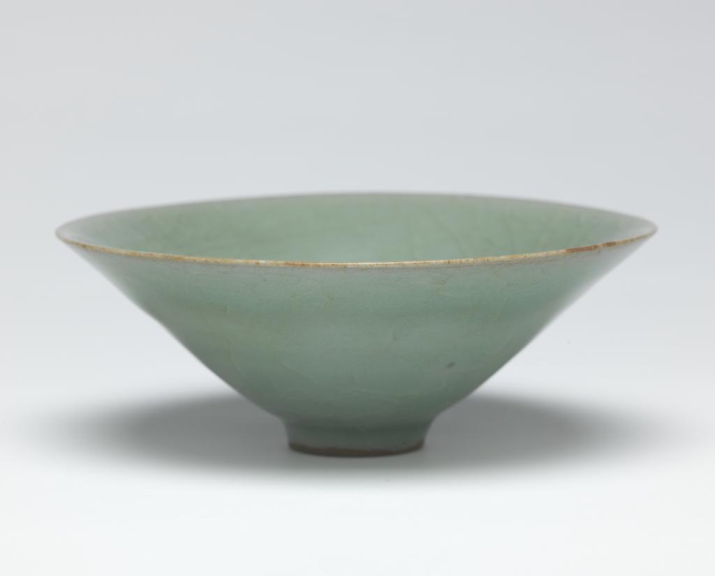 An image of Bowl. Conical bowl with thick celadon glaze, possibly Hangzhou type. Diameter, 14.6, cm. Song Dynasty (960-1279). Chinese. Acquisition Credit: Lent to the museum by Helen H. L. Whittow (nee Malcolm).