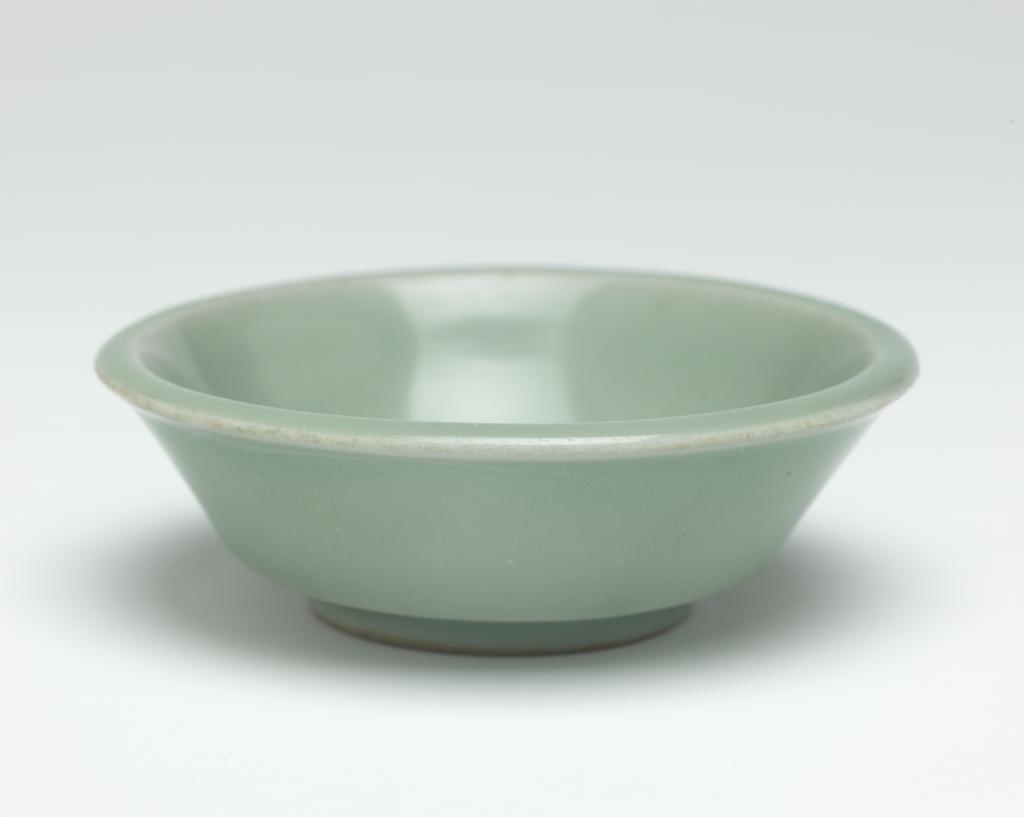 An image of Saucer. Longquan Kilns, Zhejiang, China. Straight-sided deep saucer, decorated with a good heavy Kinuta bluish-celadon glaze. Diameter 10.2 cm. Song Dynasty (960-1279). Acquisition Credit: Lent to the museum by Helen H. L. Whittow (nee Malcolm). Acquisition Credit: Lent to the museum by Helen H. L. Whittow (nee Malcolm).