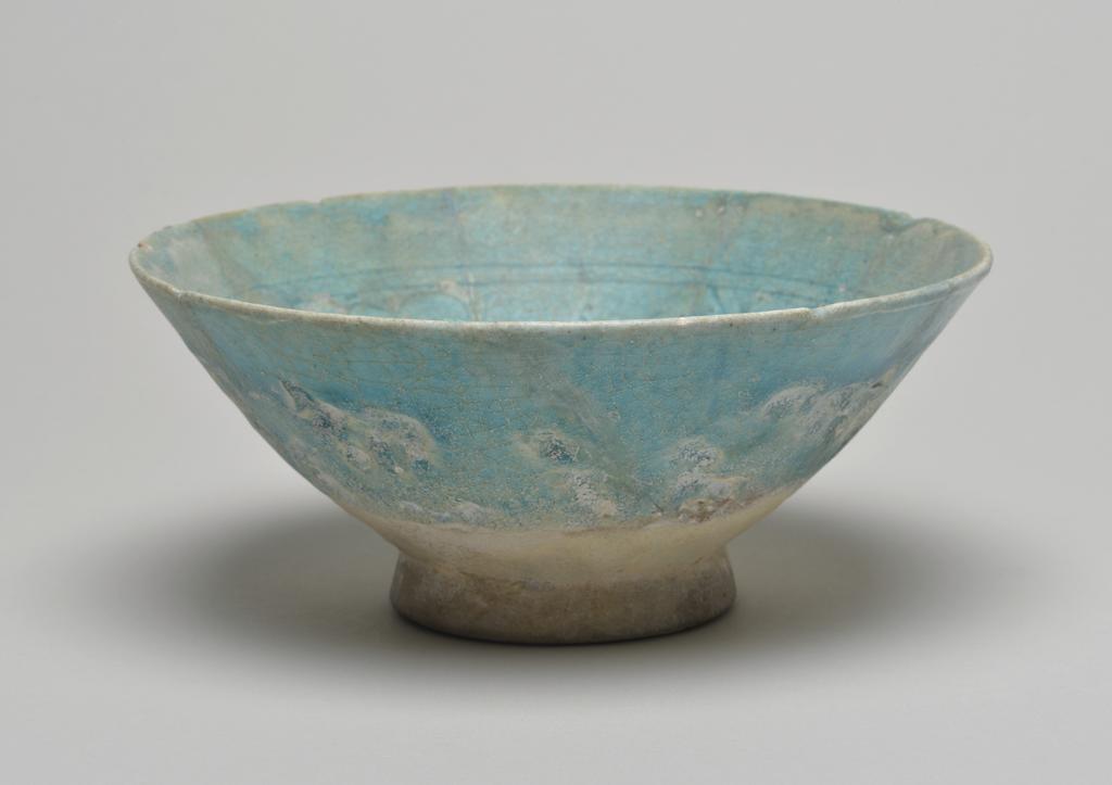 An image of Studio Ceramics. Fritware bowl. Covered in a turquoise (copper) glaze, with piercings through the body to give translucent areas. Production Place: Kashan, Iran. 1150-1250. Acquisition: Dr John Shakeshaft Bequest.