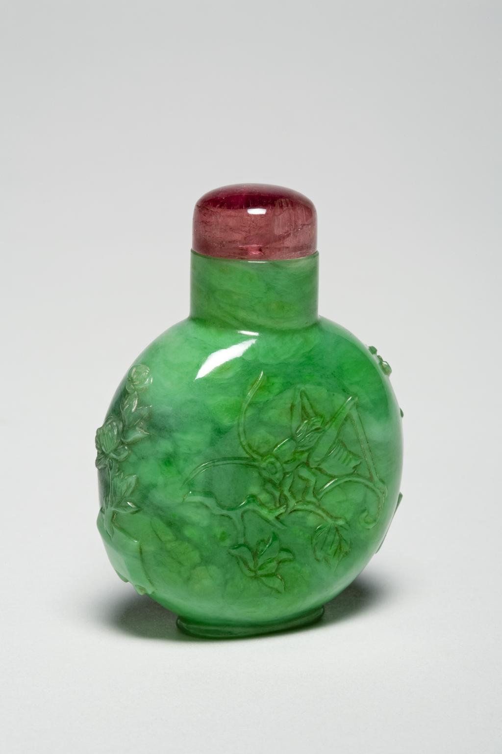 An image of Snuff bottle. Decorated with a continuous scene of birds amid peony blossoms and perched in a gnarled tree. Glass with famille rose enamels in red, orange, and yellow tones imitating realgar, height 6.2 cm, 1730-1850. Chinese. Qing Dynasty (1644-1912).