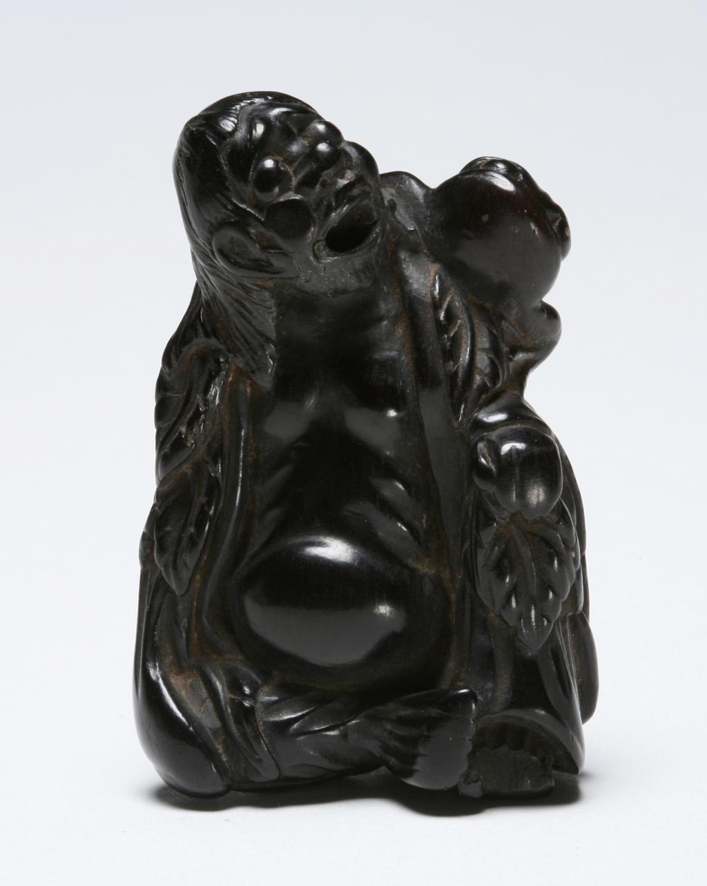 An image of Netsuke. Unknown maker, Japan. Gama Sennin clutching his magic toad by a hind-leg, unsigned. Wood, carved, height, whole, 5.6 cm, width, whole, 3.8 cm, 1700-1800.