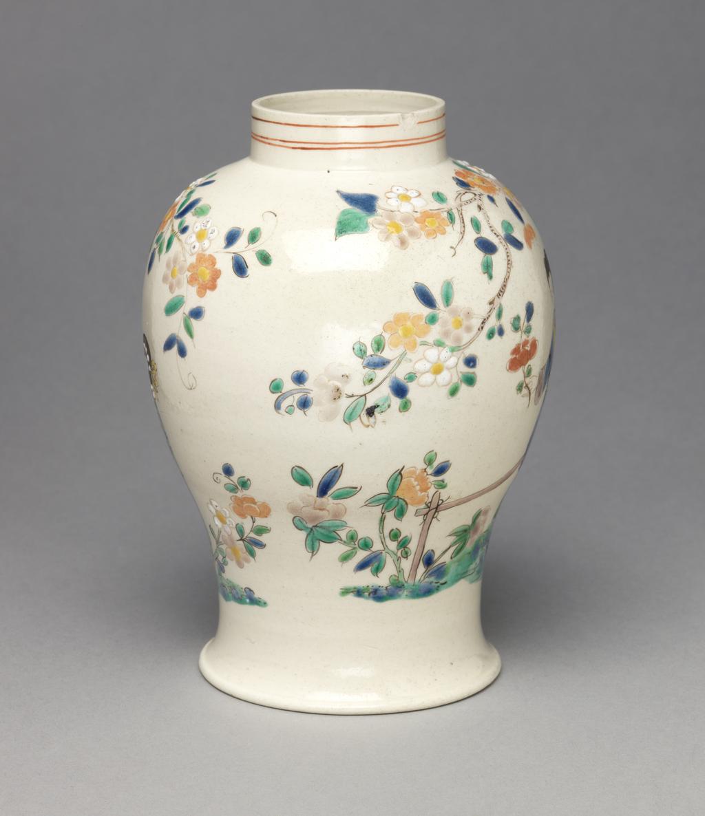 An image of Vase. Unidentified Staffordshire factory, England. Painted in polychrome enamels with Chinese figures in a garden with rocks, a fence, flowering trees and plants. Of squat meiping form with a narrow neck. The sides are decorated with a continuous Chinese garden scene. On one side, a lady stands holding a flower beside a fence with a flowering plant on the left. To her right is a rock formation and a tree with a flowering branch which extends over her. Another flowering branch extends to the right over a seated man and a standing woman. Round the neck there are three narrow red horizontal lines. Off-white stoneware, thrown, salt-glazed, and painted in blue, turquoise, green, yellow, pale salmon-pink, a little red, pale pinkish-purple, and black enamels. Height, whole, 14.7 cm, diameter, whole, 10.5 cm, diameter, foot, 7.8 cm, circa 1755-1760. Rococo. Chinoiserie. Sir Ivor and Lady Batchelor Bequest through The Art Fund.