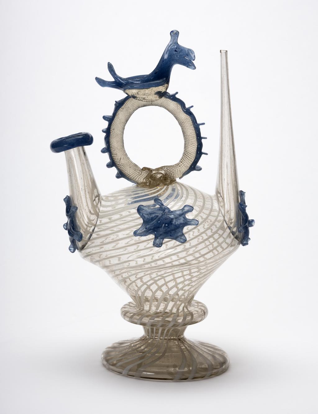 An image of Continental glass. Càntir. Pouring vessel for wine. Unknown glasshouse, Spain, Catalonia. Pale yellowish bubbly glass with opaque white threads, applied blue glass decoration and bird finial. Height, whole, 27.8 cm, width, whole, 17.3 cm, circa 1700-1750, possibly late 17th century. Production Note: A càntir is a vessel for pouring water. The word derives from the Spanish cántaro, a ceramic jug. This form is one of several typical of Catalonian glass production. Sir Ivor and Lady Batchelor Bequest through The Art Fund.