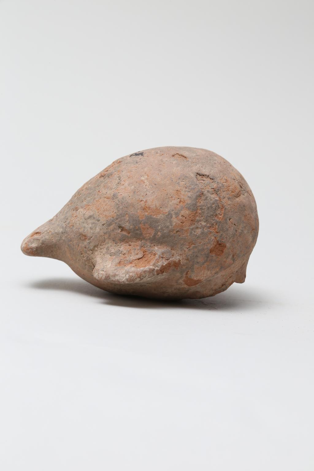 An image of Vessel. Jar, in the form of a bird ?, head missing. Find Spot: Naukratis?, Egypt. Production Place: Egypt. Height 0.105 m.