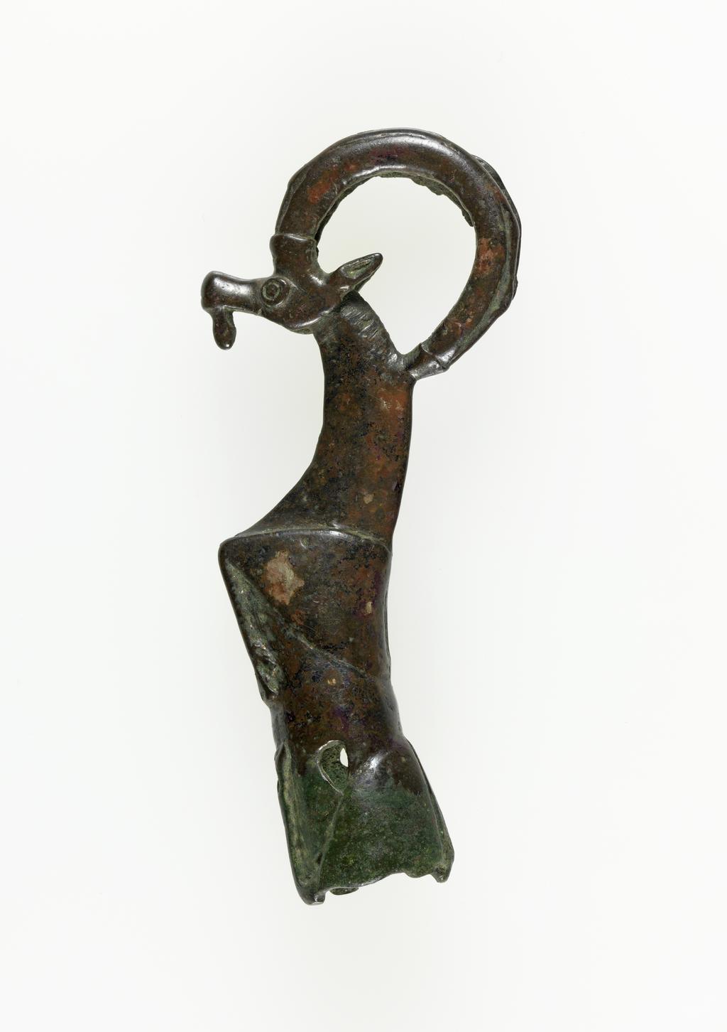 An image of Equipment. Handle of whetstone, in form of crouching ibex. Find Spot: Luristan ? Iran/Iraq. Copper alloy, circa 900-701 BC.