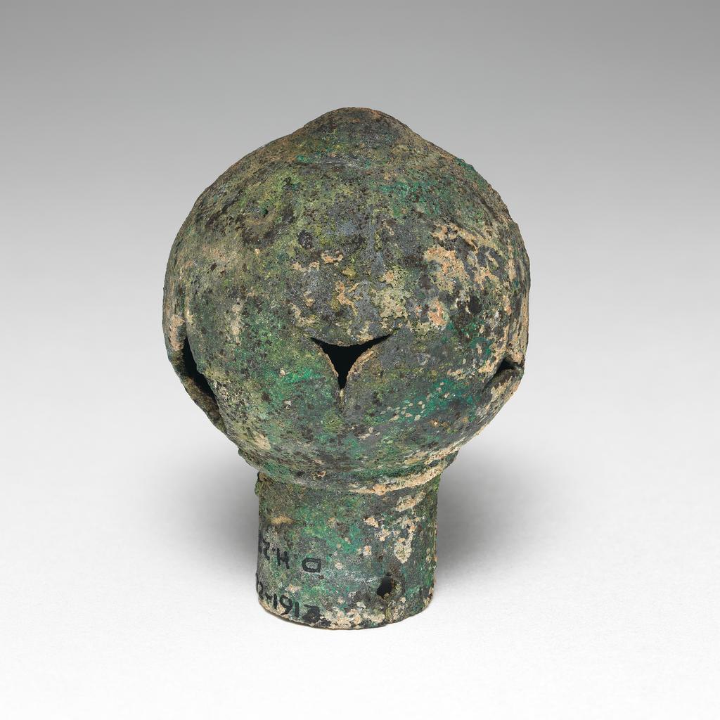 An image of Equipment. Finial. Spear butt or terminal, spherical with cut-out decoration. Production Place: Syria. Find Spot: Deve Hüyük, Syria. Copper alloy, height 6.3 cm, diameter 1.89 cm, diameter 4.57 cm.