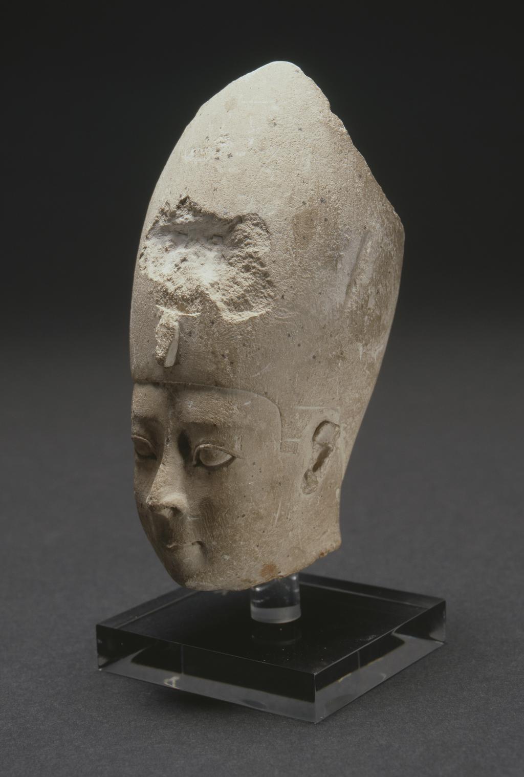 An image of Figure/statue. Head of king, wearing White Crown. The ruler wears the crown of Upper Egypt and can be identified by his closely set eyes and bloated cheeks. His cult name was Euergetes (doer of good deeds) but the Alexandrians called Ptolemy VIII 'Fatty' because of his stature. Limestone, length 10 cm, 145-116 B.C. Find Spot: Egypt. Production Place: Egypt. Reign of Ptolemy VIII.
