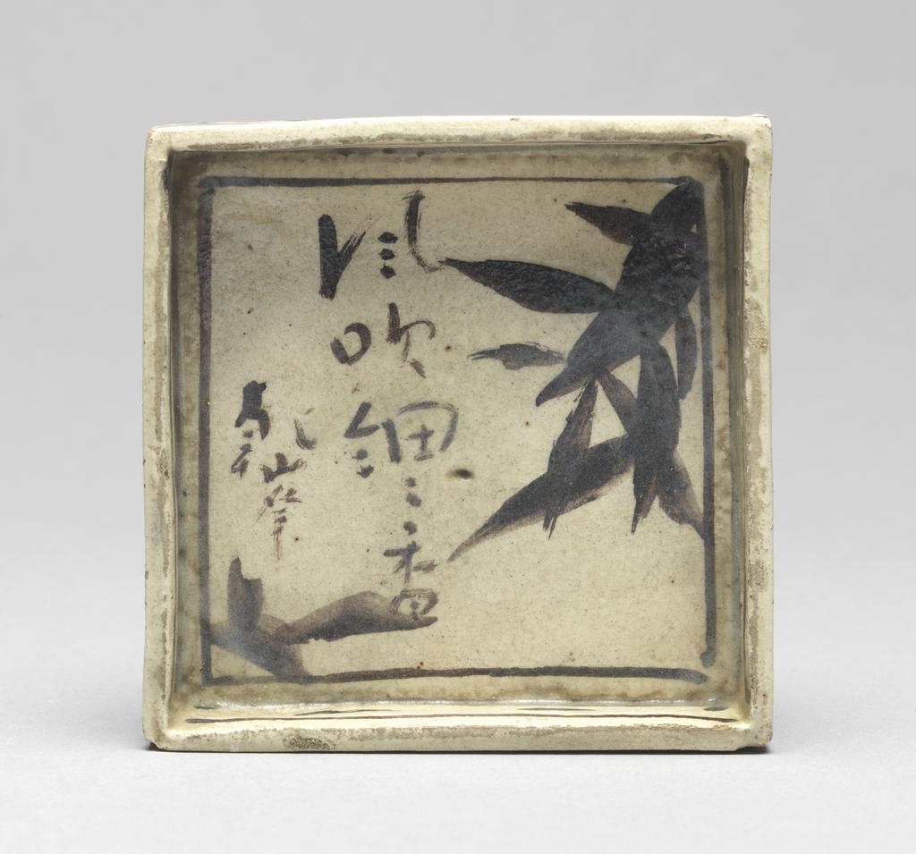 An image of Japanese pottery. Small plate for food. Kenzan, pottery studio, Japan, Kyoto. A square plate, small and shallow. Underglaze brushwork of pine in black, together with inscriptions in Chinese characters. Cloud decorations around the outside. Maker's mark and the inscription; on the plate; brushed; four Chinese characters verse inscribed by KENZAN; Four Chinese characters read ' the wind blowing to the thin bamboo branches' painted by KENZAN. Stoneware, hand-built, brush painting in black pigment, height 2.00 cm, width of the square, whole, 9.50 cm, larger, circa 1700-circa 1799. Edo Period (1615-1868). Production Note: this piece belongs to the three-piece set (C.183A, B & C-1934).