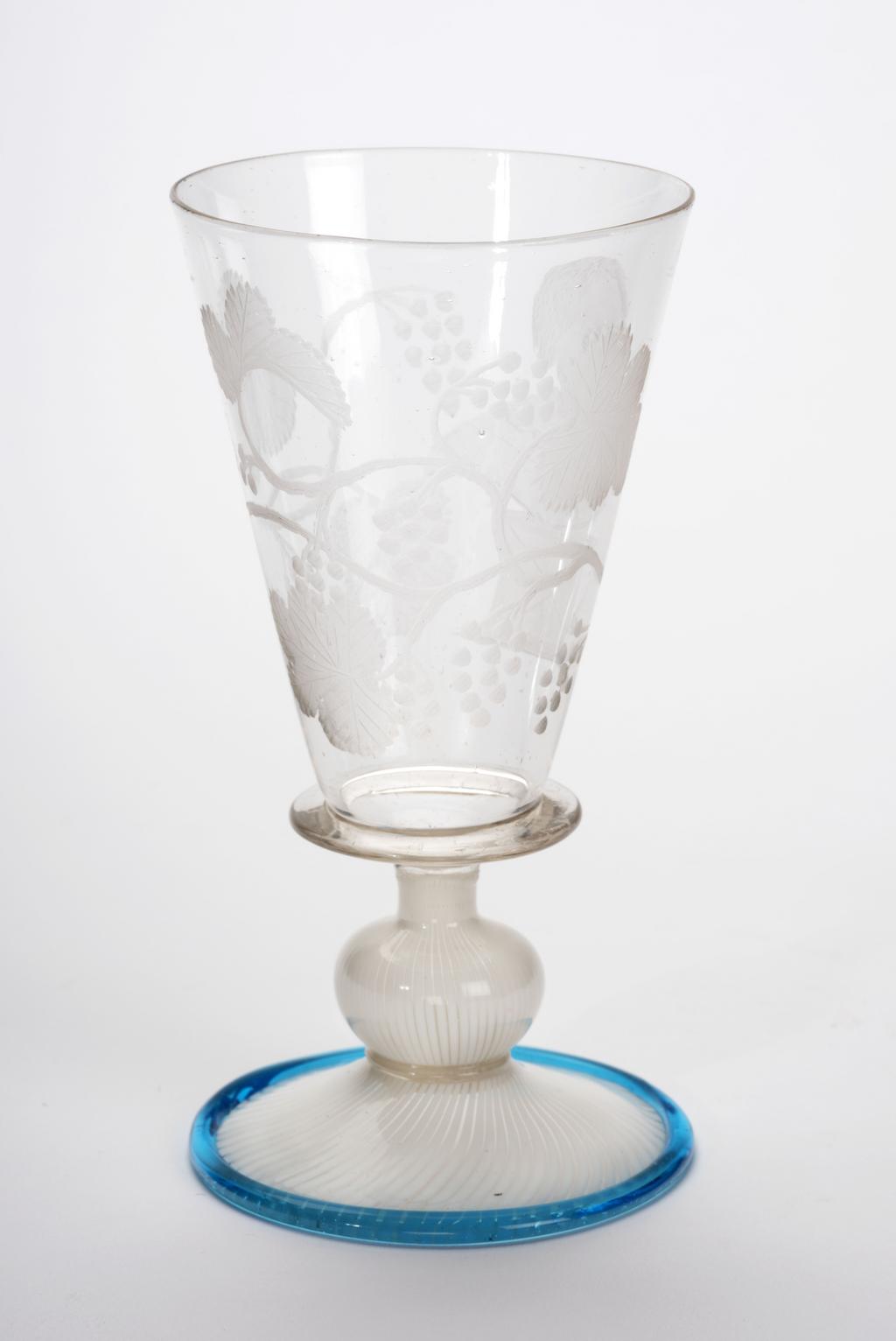 An image of Wine Glass. Façon de Venise. Plain conical bowl engraved with a portrait, probably of the infant Prince Willem III of Orange (b. 1650). Soda glass, with vetro a fili foot trailed in turquoise-blue round the edge (wheel-engraving). Height, 11.3 cm, diameter, 5.7 cm, after 1655 to before 1665. Sir Ivor and Lady Batchelor Bequest through The Art Fund.