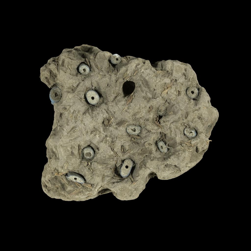 An image of Jewellery. Beads, embedded in mud. Find Spot: Thebes (Egypt), Deir el-Bahri. Height 0.07 m. Eighteenth Dynasty. New Kingdom.