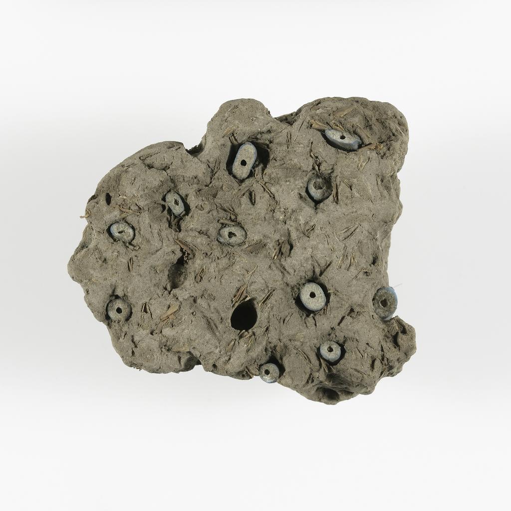 An image of Jewellery. Beads, embedded in mud. Find Spot: Thebes (Egypt), Deir el-Bahri. Height 0.07 m. Eighteenth Dynasty. New Kingdom.