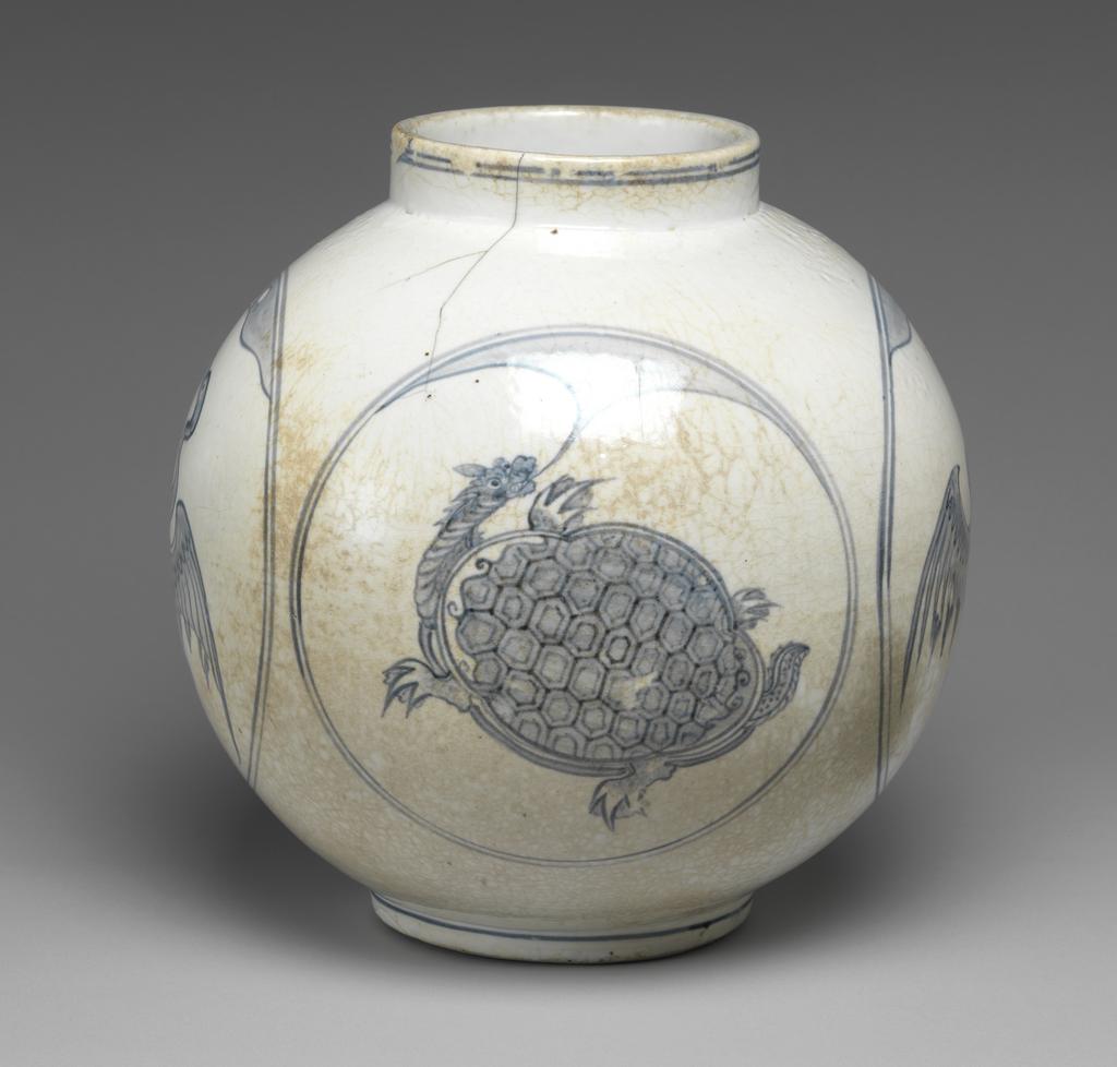 An image of Large jar with tortoise and crane designs. Unknown pottery, Korea, Kwangju, Punwon-ri kilns. The body of this jar is almost globular and the neck straight; the foot is wider than the neck, giving the jar a stable appearance. In four roundels around the sides, divine tortoises and cranes are arranged in alternation, with a cloud or auspicious vapour issuing from the mouth of each tortoise, and with lots of free space around the designs. The glaze is of milky-white colour and crackled, the body is thick and heavy. On the base is an unexplained straight incised line and traces of sandy supports adhere to the footring. Porcelain, thrown, painted in cobalt-blue, and glazed, height, whole, 31.0 cm, diameter, rim, 14.0 cm, diameter, foot, 15.0 cm, circa 1750-1800. Choson Dynasty (1392-1910). Notes: Such jars (hangari) were used as wine vessels.