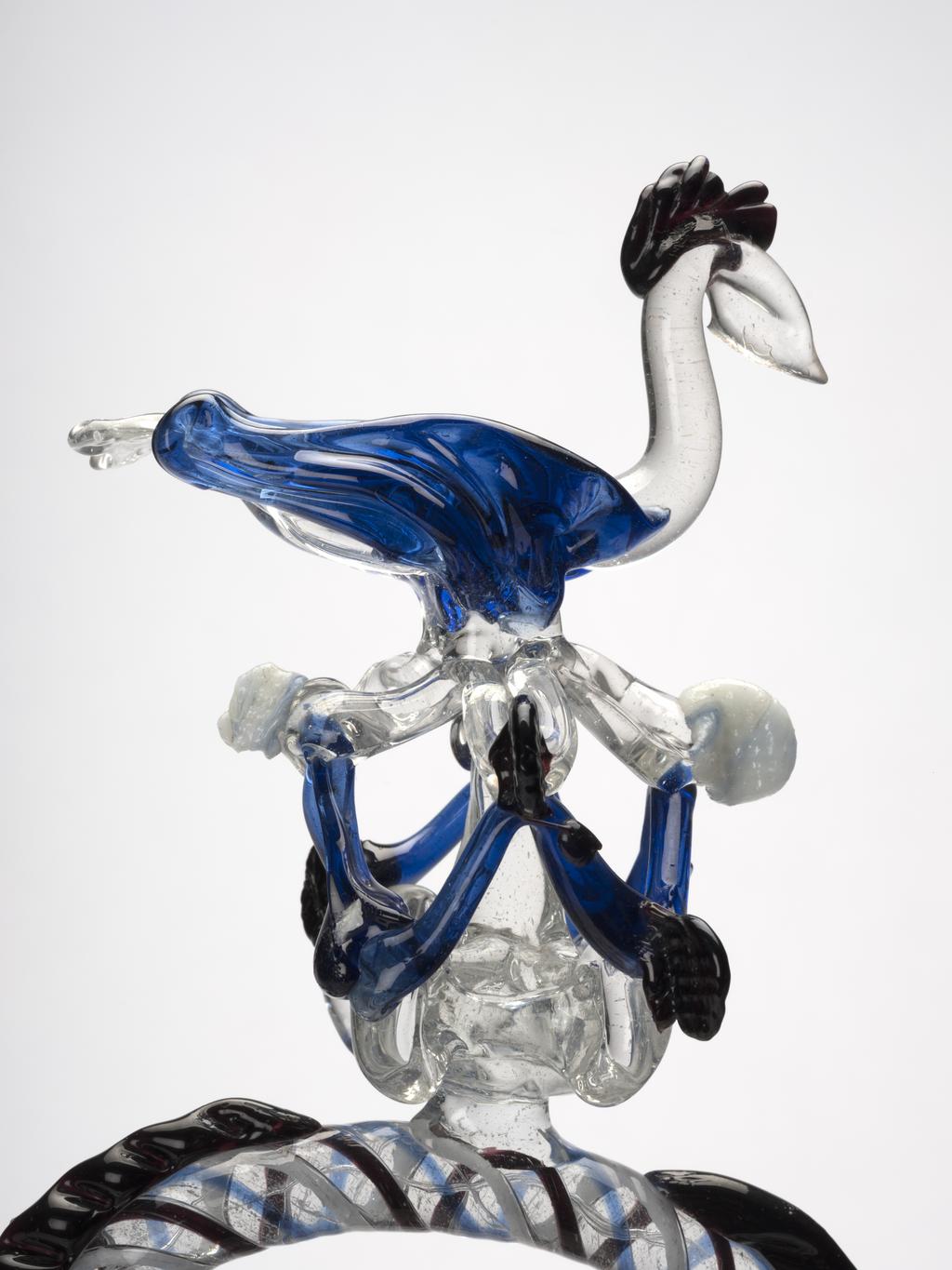 An image of Continental glass. Càntir. Pouring vessel for wine. Façon de Venise. Unknown glasshouse, Spain, Catalonia. With bird finial. Clear and blue glass, blown, height, 44 cm, width, 23.5 cm, after 1650 to before 1800.  Production Note: A càntir is a vessel for pouring water. The word derives from the Spanish cántaro, a ceramic jug. Sir Ivor and Lady Batchelor Bequest through The Art Fund.