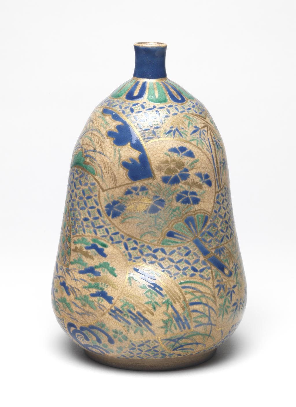 An image of Japanese pottery. Sake bottle. Awata ware. Unknown pottery, Japan, Kyoto. Footed bottle of gourd shape with narrow neck, thrown, turned and altered, with two indentations on one side. Decorated with light buff glaze and overglaze enamels of varied floral decoration in blue, green and gold, displayed in fan shaped panels on a SHIPPO background. Stoneware, glazed, height, whole, 19.90 cm, diameter, rim, 2.00 cm, diameter, bottle, 12.50 cm, diameter, foot, 8.60 cm, circa 1700-circa 1799. Edo Period (1615-1868).