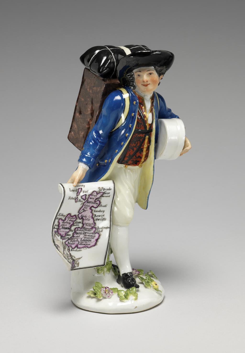 An image of A map-seller. Meissen Porcelain Manufactory, Saxony. With his right hand he holds out a map of the British Isles, in the lower proper right corner figures of Mercury and Britiannia with a bale of merchandize. Under his left arm he carries a white band box. On his back, slung from his shoulders by yellow straps, he carries a mottled-brown cabinet with nine drawers, on top of which is a black hold-all secured by a broad cream-coloured strap. Hard-paste porcelain, press-moulded, glazed, and painted in enamels and gilt, height, whole, 16.9 cm, width, 10 cm, circa 1750-1755. After a model of 1744. Production Note: This model was based on the first print of the third set of Etudes prises dans le bas peuple ou les Cris de Paris, issued in 1738, engraved by the comte de Caylus (1692-1765) after drawings by Edmé Bouchardon (1689-1762) . It is smaller than the first figure modelled after this engraving in 1744. Unusually, the map seller holds a map of the British Isles.