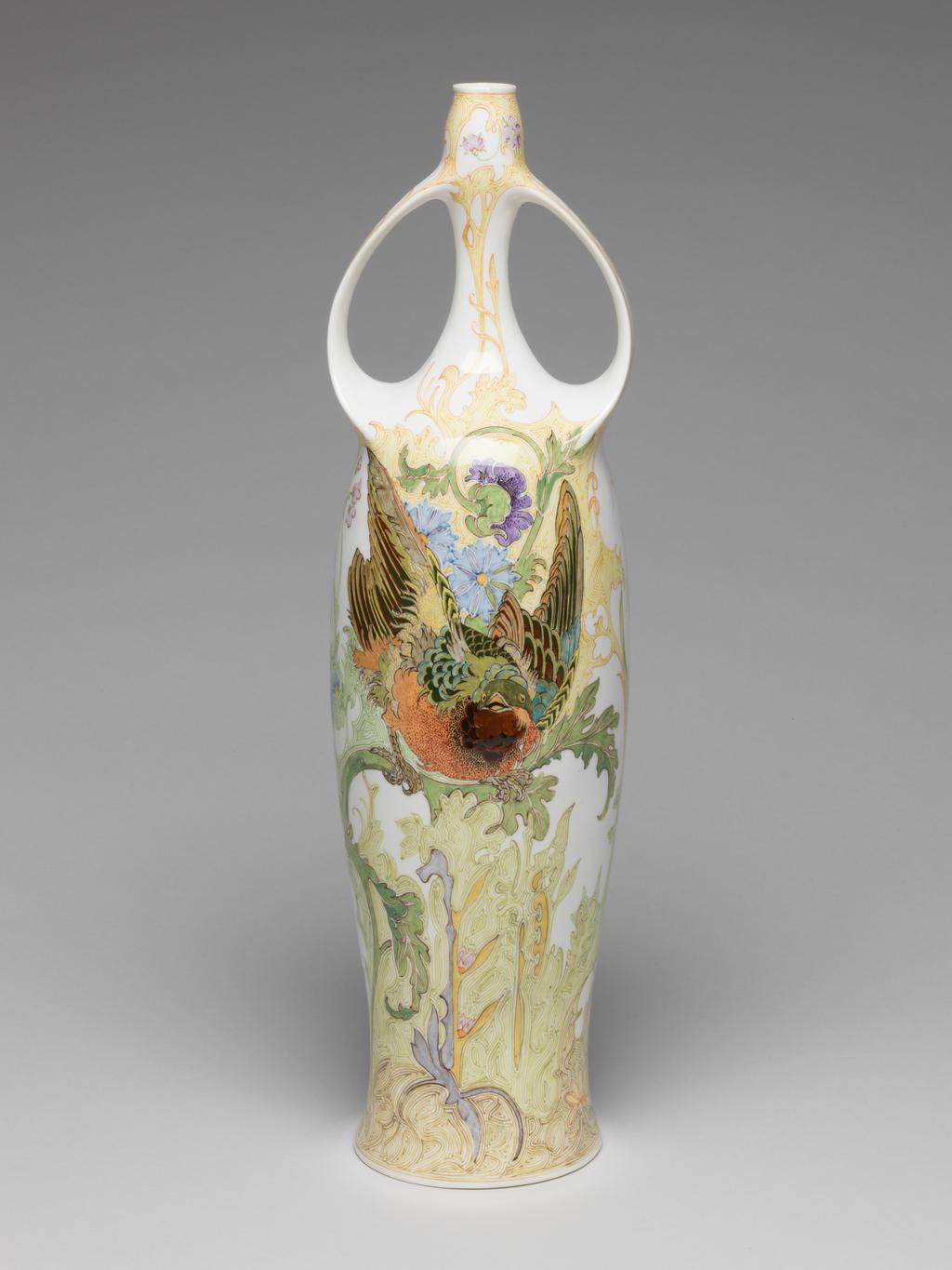 An image of Pair of two-handled balaster vases. Tegel en Fayencefabriek Amphora Factory, Oegstgeest. Designed by J. Jurriaan Kok (Dutch, 1861-1919). Painted by Samuel Schellink (Danish, 1876–1958). C.28-2014: Tall eggshell porcelain vase, baluster shape, hand-painted in polychrome enamels with bird, poppy and foliage motifs in Art Nouveau style. Circular in plan, with tall gently-concave body rising to a long narrow neck, the top of the neck slightly wider than the bottom. Two strap handles, cast with the body, rise from the shoulders and rejoin the vase towards the top of the neck. The overall form suggests an erect female body with arms raised to her head. Decorated with a finely painted flowing floral design. On one side is a green-headed songbird which appears to be flying out of the body. On the other side is a large spray of purple and light blue oriental poppies. Eggshell porcelain, decorated underglaze in polychrome enamels with hand-painted motifs, height 36.5 cm, base width 8.5 cm, circa 1914.C.29-2014: Tall eggshell porcelain vase, baluster shape, hand-painted in polychrome enamels with bird, poppy and foliage motifs in Art Nouveau style. Circular in plan, with tall gently-concave body rising to a long narrow neck, the top of the neck slightly wider than the bottom. Two strap handles, cast with the body, rise from the shoulders and rejoin the vase towards the top of the neck. The overall form suggests an erect female body with arms raised to her head. Decorated with a finely painted flowing floral design. On one side is a black-headed songbird which appears to be flying out of the body. On other side is a large spray of orange oriental poppies. Eggshell porcelain, decorated underglaze in polychrome enamels with hand-painted motifs, height 36.5 cm, base width 8.5 cm, circa 1914.