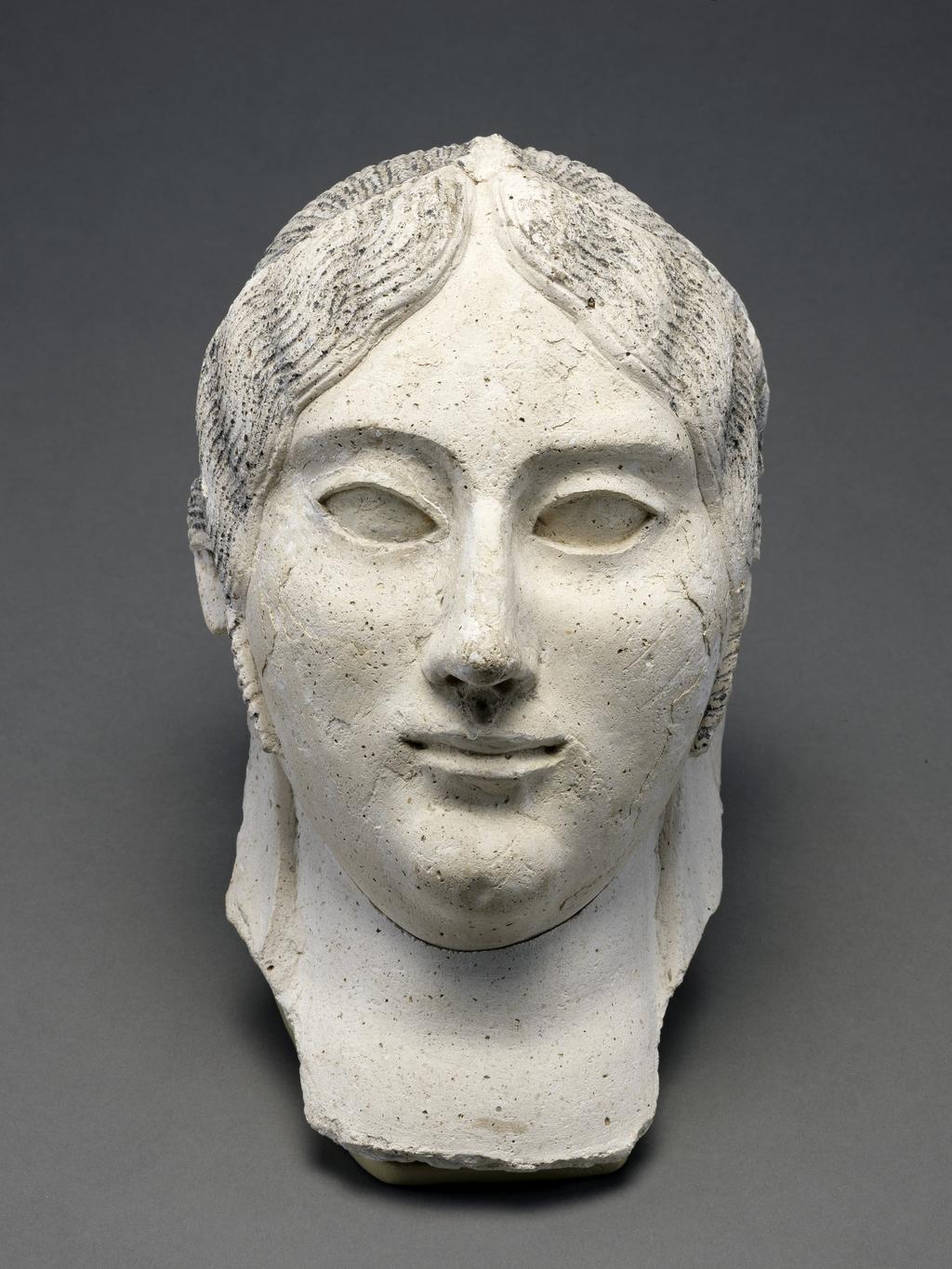 An image of Mask of a woman. These faces formed the top section of a type of coffin that was popular in Roman Egypt. The facial features and hairstyles of the examples here seem individual. However, such masks were mass-produced by pouring plaster in moulds. Production Place: Egypt. Mould made, plaster, depth, 20, cm, height, 29, cm, width, 14, cm. Roman, 100-150 AD, reign of Hadrian.