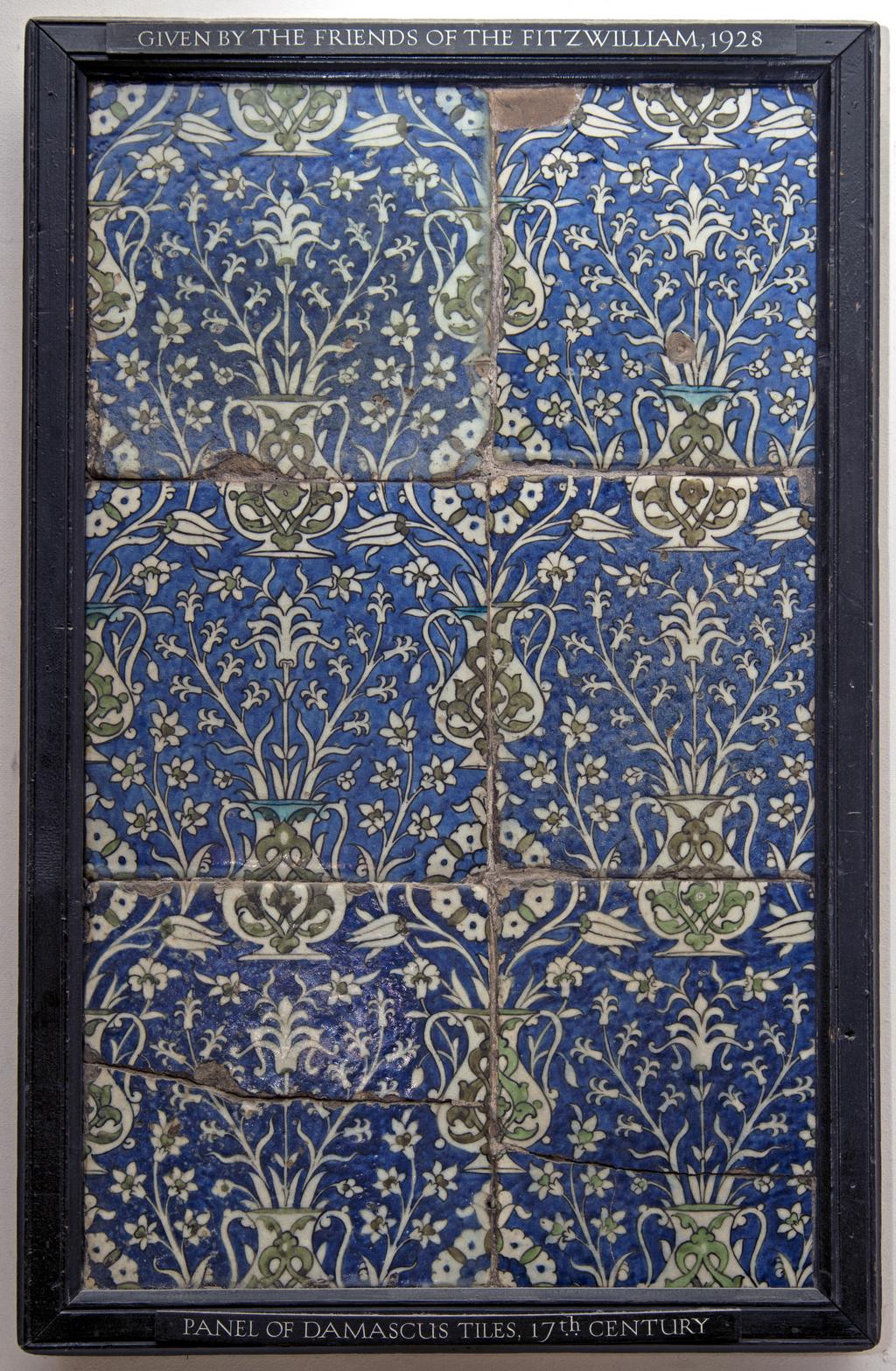 An image of Fritware (stonepaste) tile panel. Islamic pottery; Iznik style. Fritware, mould made, painted in blue and green with touches of turquoise and black outlines, all under a clear glaze. Height, whole, 76cm, width, whole, 50cm.  Ottoman, circa 1550-1699. Levant, Syria, Damascus.