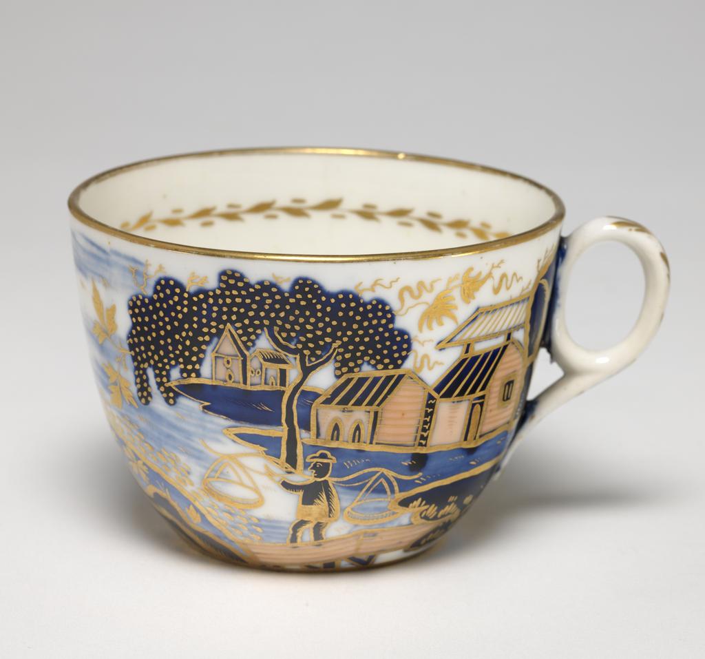 An image of Cup and Saucer/Teacup. New Hall Porcelain Factory, Staffordshire. The cup is of Bute shape with oval ring handle. The saucer is circular with curved sides, standing on a footring. The cup is decorated on the exterior with an Oriental landscape with buildings on the left and right, a man standing fishing on a bridge, a man in a boat, and a larger man in the middle. Inside below the rim there is a continuous horizontal spray of leaves in gold. There is a gold band round the rim, and six stylized leaves down the back of the handle. The interior of the saucer is decorated to match the exterior of the cup and has a gold band round the rim. Pattern 1163. Bone china, painted underglaze in blue, overglaze in apricot-pink enamel, and gilded. Height, cup, 6 cm, width, cup, 10.5 cm, diameter, cup, 8.5 cm, height, saucer, 3.5 cm, diameter, saucer, 14.5 cm, circa 1815-1820. Imari style.