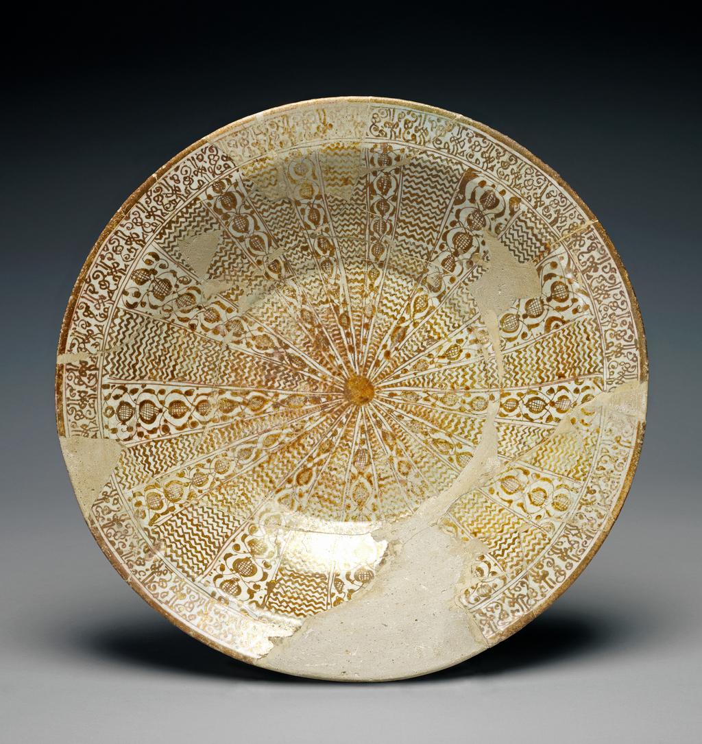 An image of Fritware (stonepaste) / Dish. Pinkish fritware, wheel thrown, white, slightly crazed, glaze painted with yellow-brown lustre, height 7.6 cm, width 34 cm, diameter (rim) 34 cm, diameter (base) 13.5 cm, circa 1179-1198. Seljuk; miniature style. Iranian.