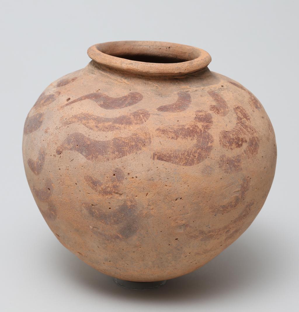 An image of Vessel. Jar, broad shouldered, globular form, with comma shaped decoration in red paint. Production Place: Egypt. Find Spot: Ballas, Egypt. Height, 0.155, m. Predynastic period.