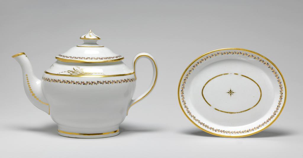 An image of Teapot and stand. New Hall Porcelain Factory, Staffordshire. The teapot and cover (A) are of oval ogee form. The stand (B) is oval with sloping sides and flat base. There are ten holes forming an ellipse surrounding one hole behind the spout, one ventilation hole in the cover, and anothe under the knob. The exterior of the pot is decorated below the shoulder by border comprising a wavy black stem with tiny trefoil leaves, puce berries, and gold trefoil leaves. Above the shoulder there is an an arrangment of gold foliage on each side of the pot and a gold sprig at each end. Gold bands run found the footring, the shoulder, the rim, the sides of the handle, and the tip of the spout. There is a vertical gold line down the back of the handle. Each side of the spout is decorated with a row of gold stars over a line which runs on round its junction with the body. Below the lip there is a gold wavy dotted line over a vertical row of narrow leaves altenating with spots. The cover is decorated en suite, and has eight swirling gold lines radiating from the top of the knob. The stand has a central stylized star-like flower surrounded by an oval gold band, a matching border, and a gold band on the edge. Pattern no. 280. Hybrid hard-paste porcelain, moulded, glazed, painted overglaze with black and puce enamel, and gilded. Height, teapot, 17.5 cm, length, teapot, 24.2 cm, height, stand, 2 cm, length, stand, 17.7 cm, width, stand, 14.6 cm, circa 1797-1803.